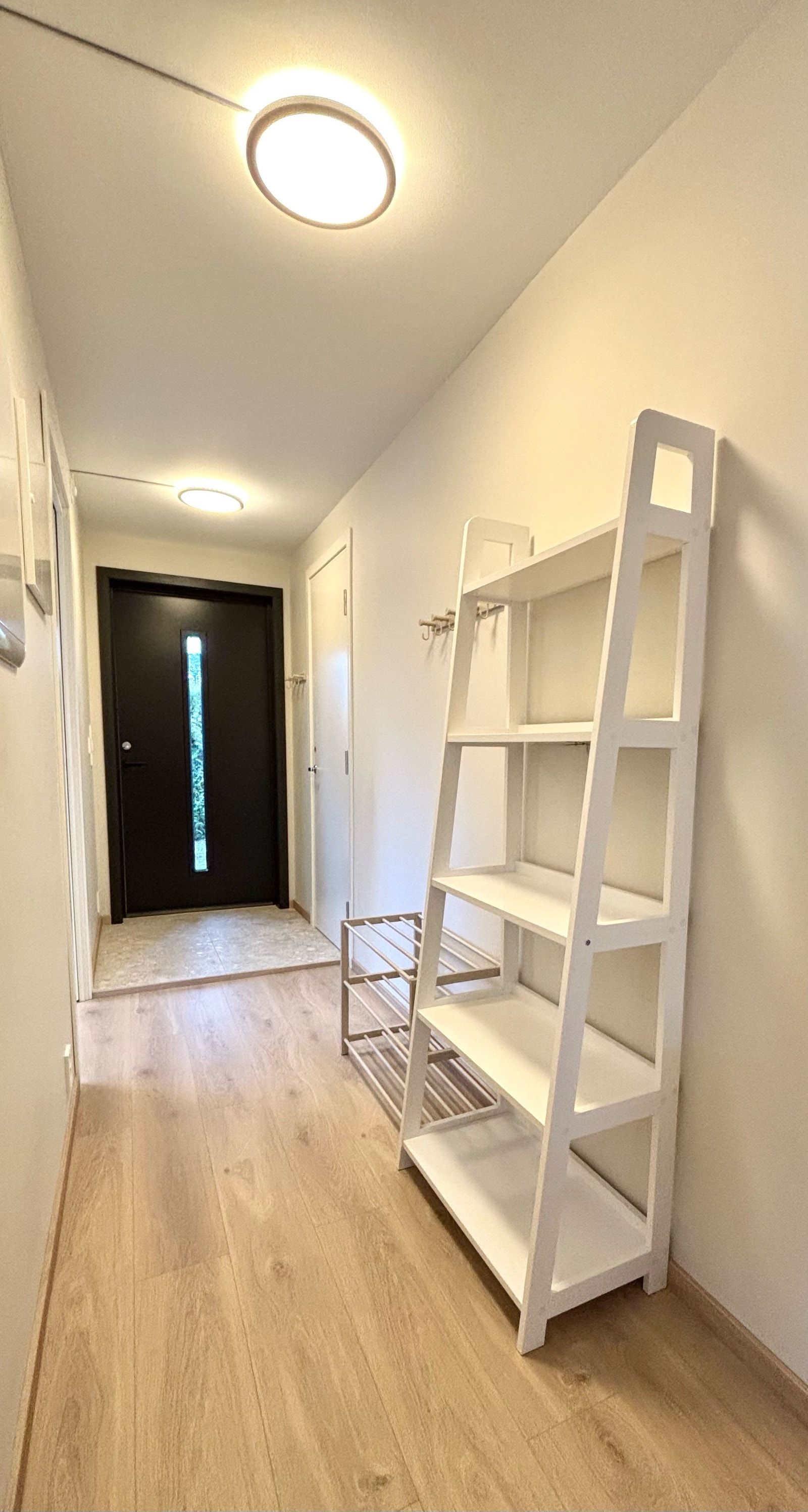 Lys gang med knagger og hyller. Galleribilde