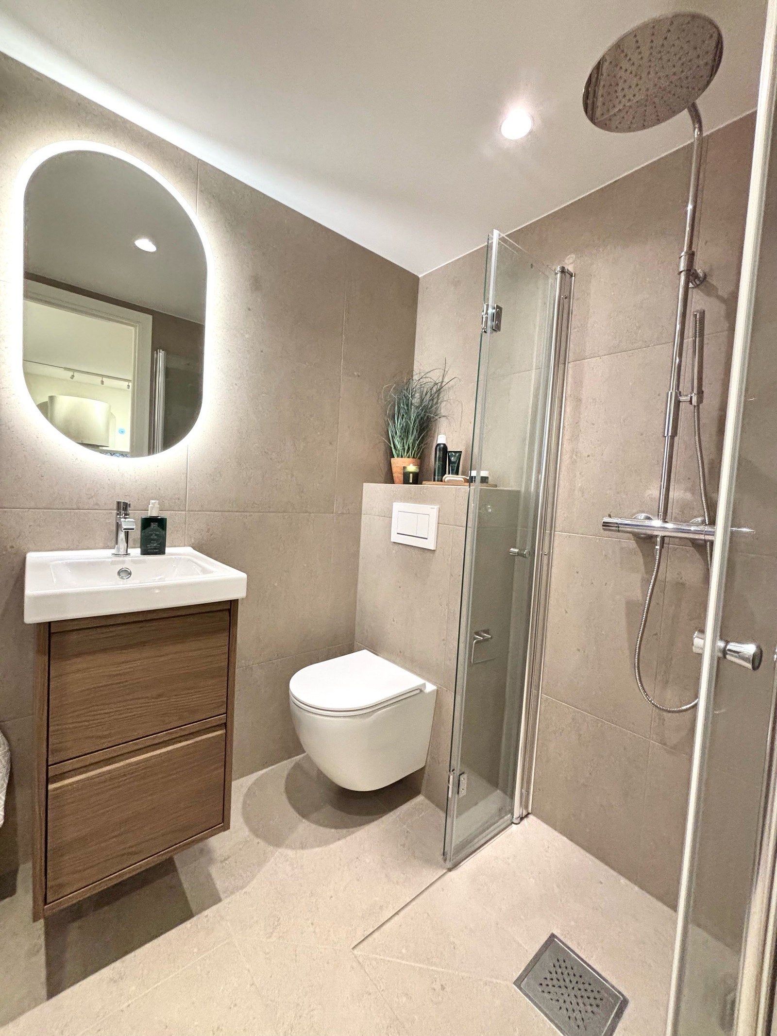 Flislagt bad med spotter i tak og speil med lys. Galleribilde