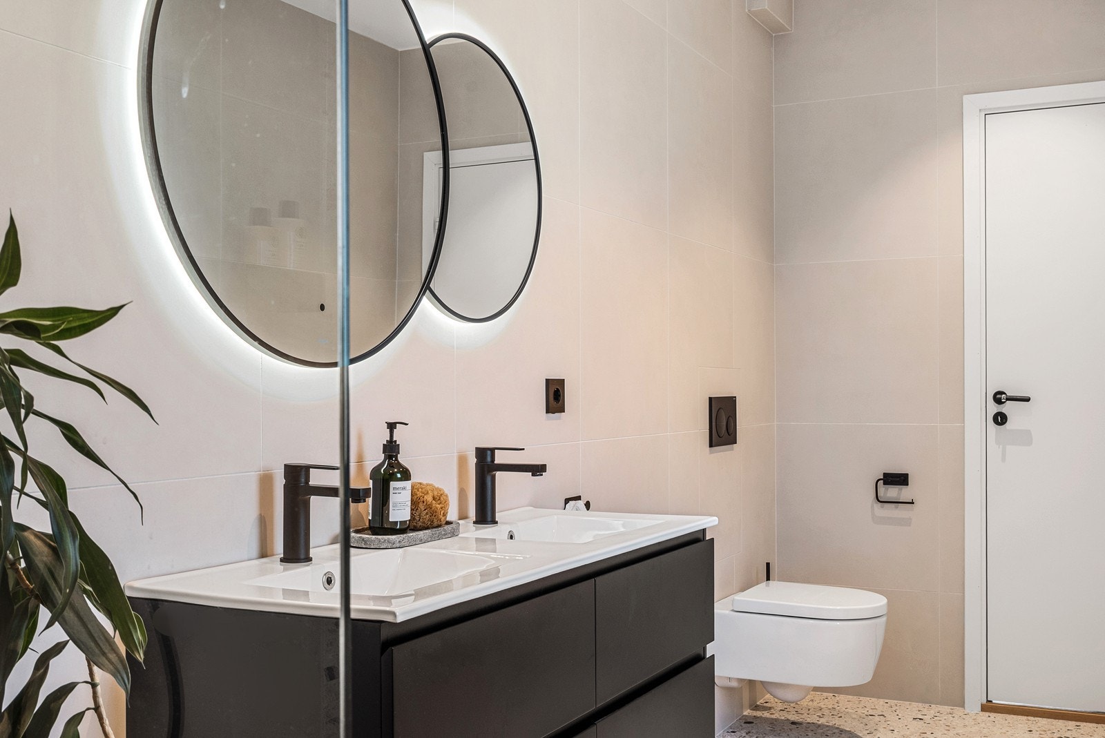 Badet i andre etasje har flislagte overflater, gulvvarme, downlights og moderne innredning. Det er utstyrt med dobbel servant med skuffeseksjon, speil og vegghengt toalett. Galleribilde