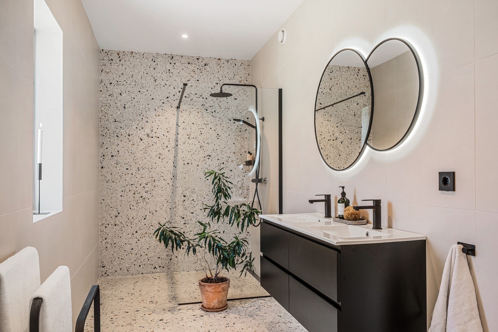 Dusjsonen er adskilt med glassvegg og har både hånd- og takdusj, armaturene er i sort. Galleribilde