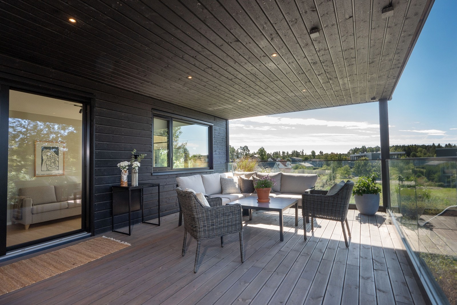 Uteplassen har terrassebord på gulv, downlights og moderne rekkverk i klart glass. Her kan du enkelt ta med måltidene ut! Galleribilde