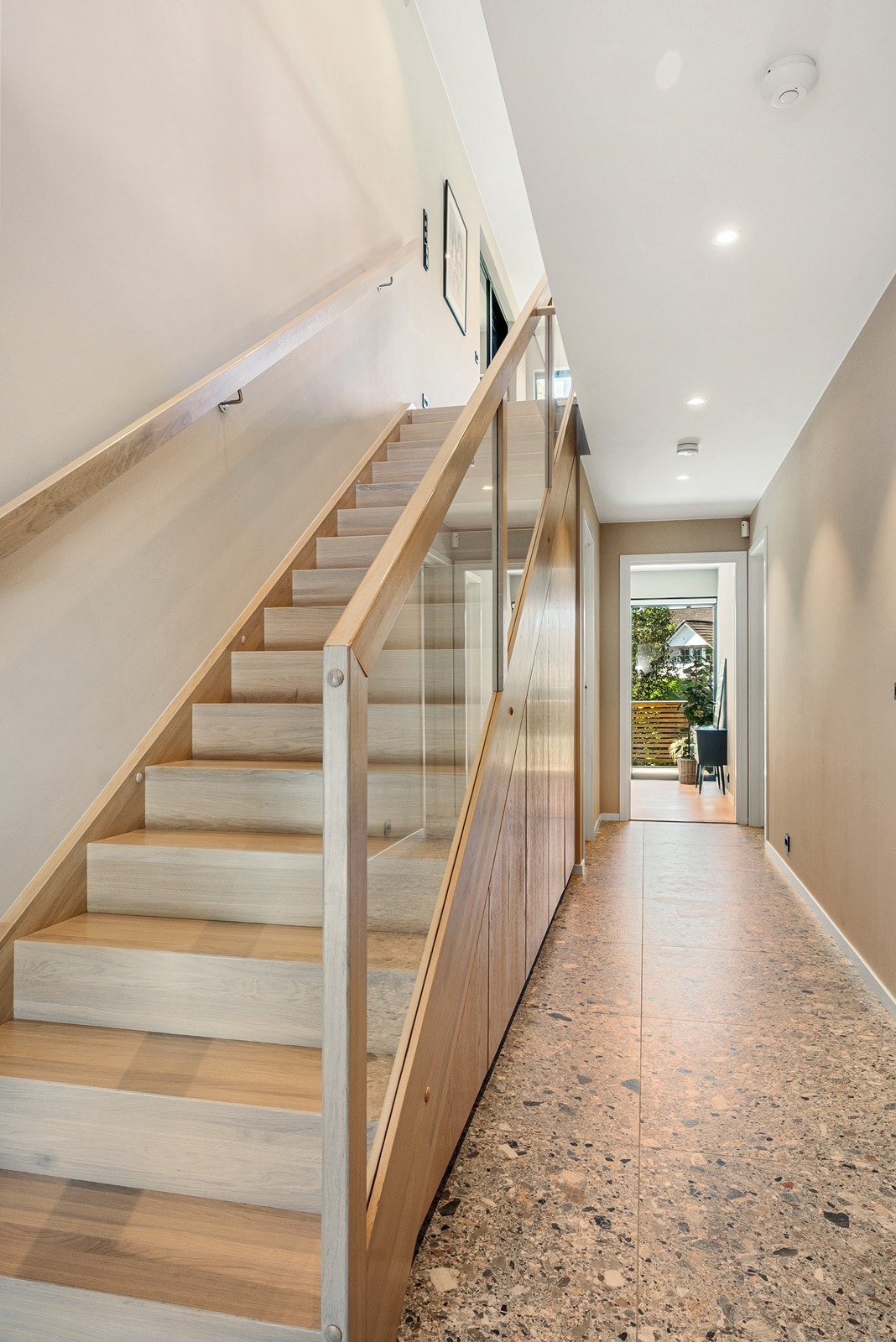 Eiketrapp med tette opptrinn, glassrekkverk og håndløper i eik gir et godt førsteinntrykk. Under trappen er det garderobeløsning. Galleribilde