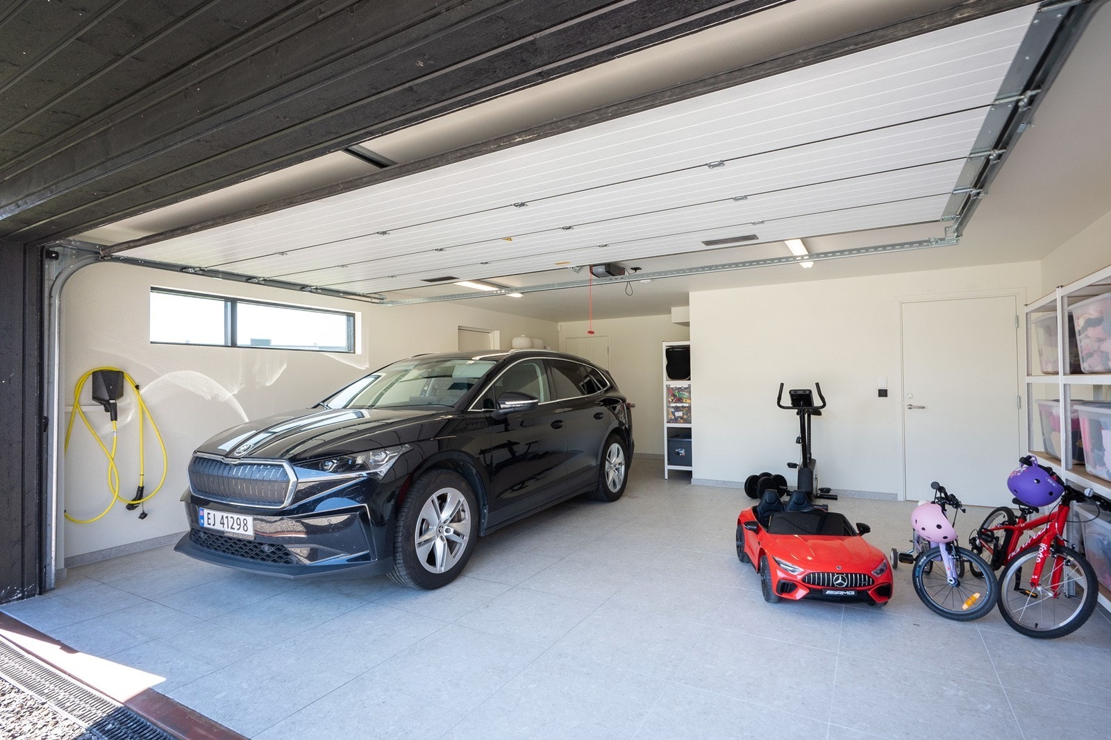 Parkering på egen gårdsplass eller i integrert dobbelgarasje med innvendig adkomst til vaskerommet, som gir mulighet for tørrskodd rett inn i boligen. Det er montert utekran med varmt og kaldt vann. Galleribilde