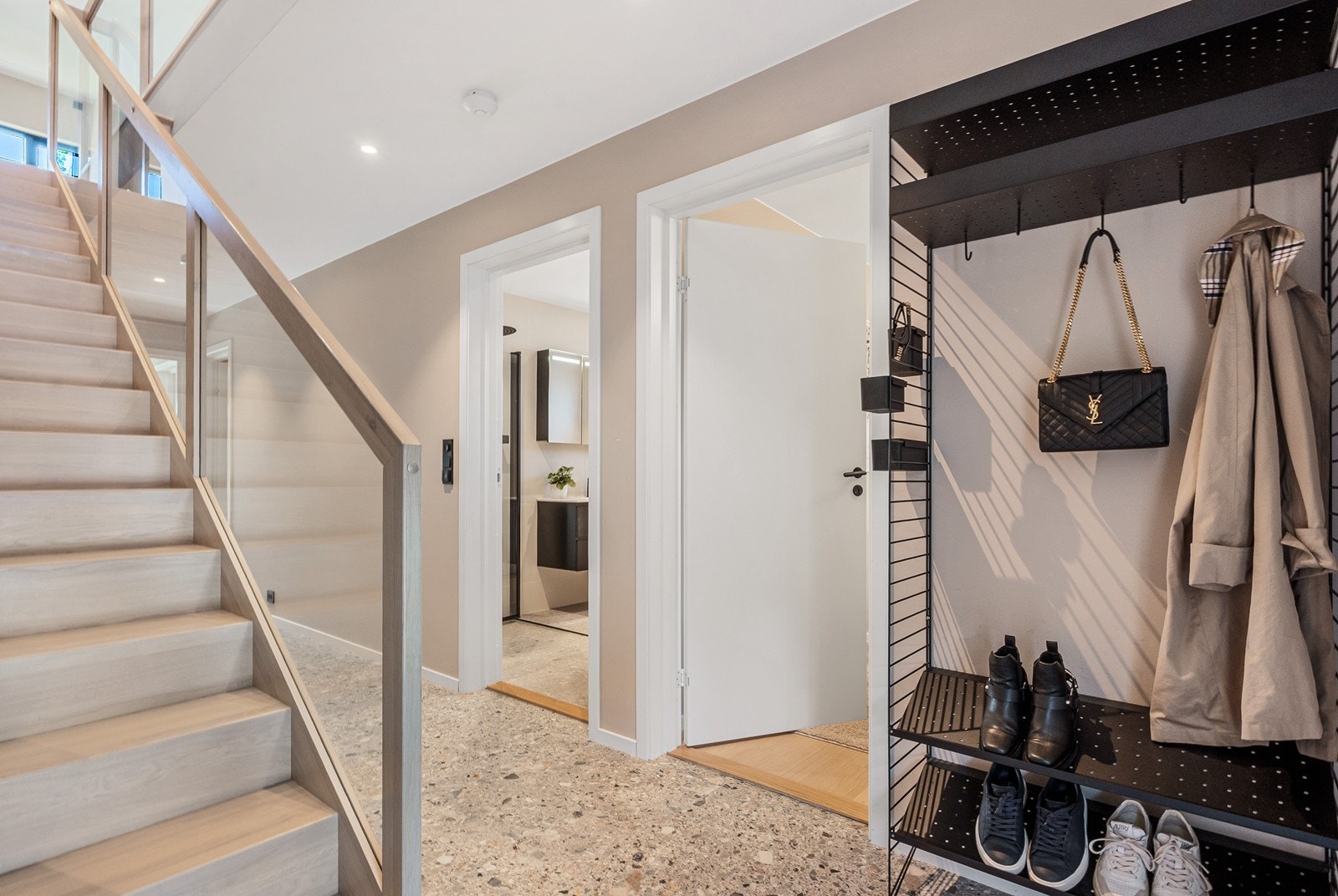 Innenfor døren møtes du av flislagt gulv, lyse overflater og plass til oppbevaring av yttertøy. Galleribilde