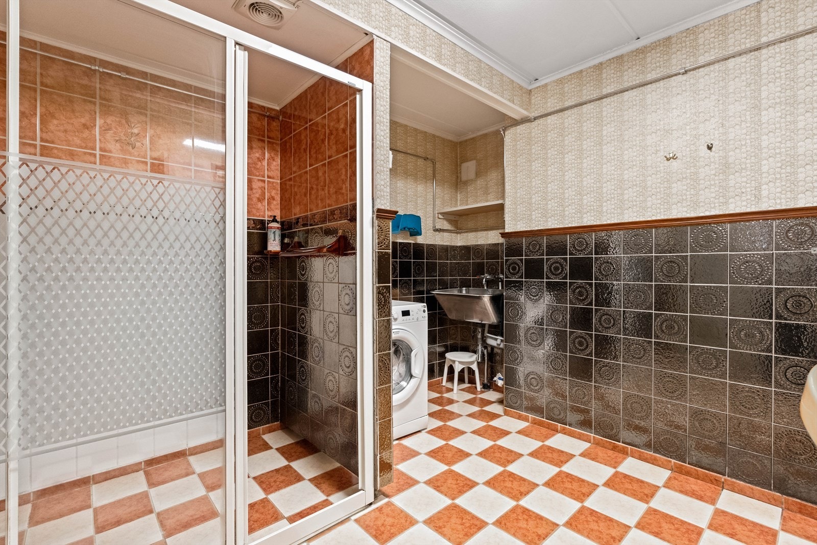 Leiligheten har et bad med flislagte overflater, samt med tapetserte overflater over brystningen. Rommet har dusj på gulv med dører i herdet glass, servant og utslagsvask i rustfritt stål. Galleribilde