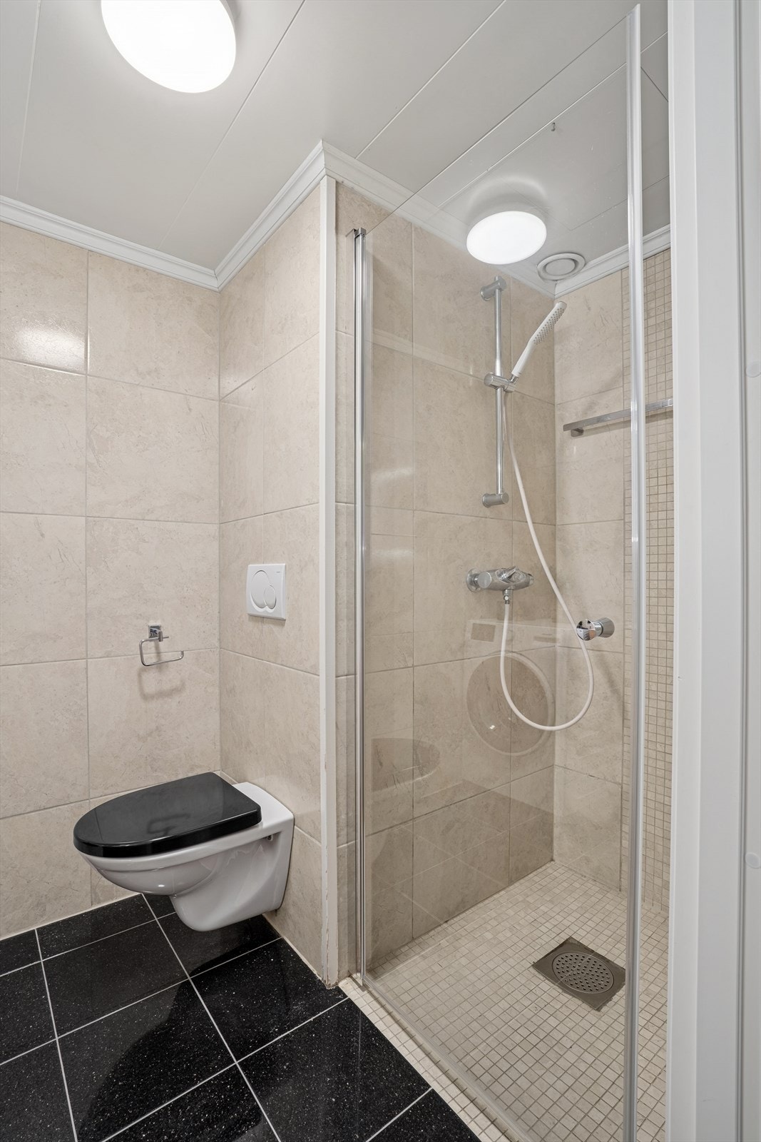 Badet er et ferdigbygd baderomskabin med flislagte overflater og gulvvarme. Galleribilde