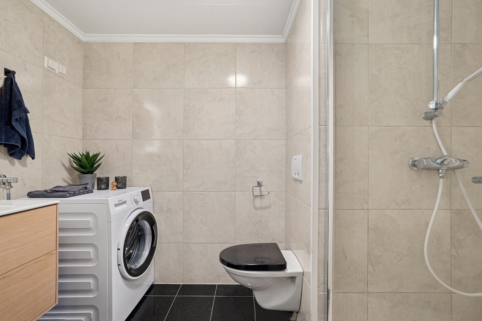 Badet er utstyrt med nedfelt servant, speil med lys og overskap, veggmontert klosett, dusjhjørne med ny dusjdør og røropplegg til vaskemaskin. Galleribilde