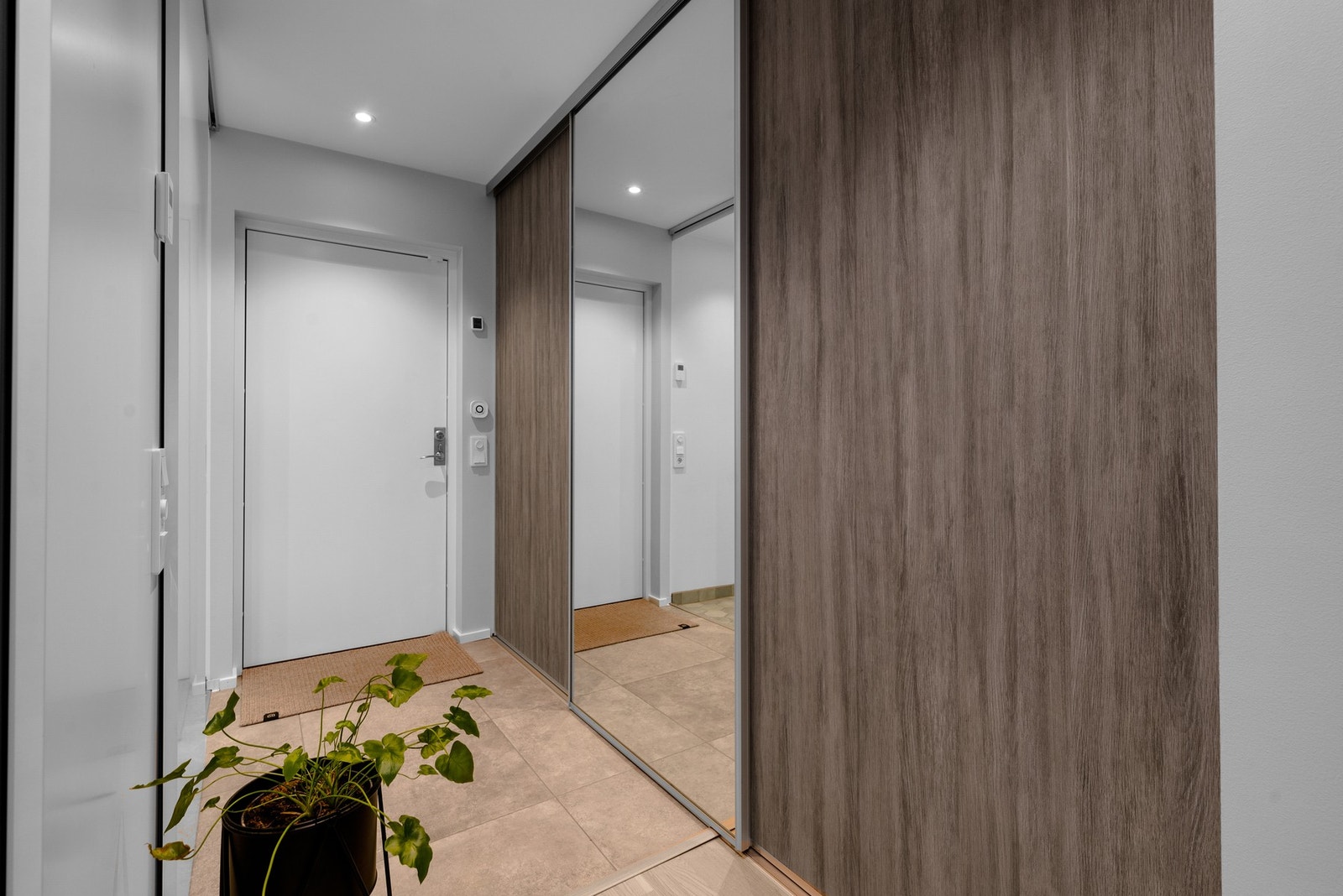 Innbydende entré med flislagt gulv, skyvedørsgarderobe med speilfronter og god plass til oppbevaring yttertøy og sko. Galleribilde