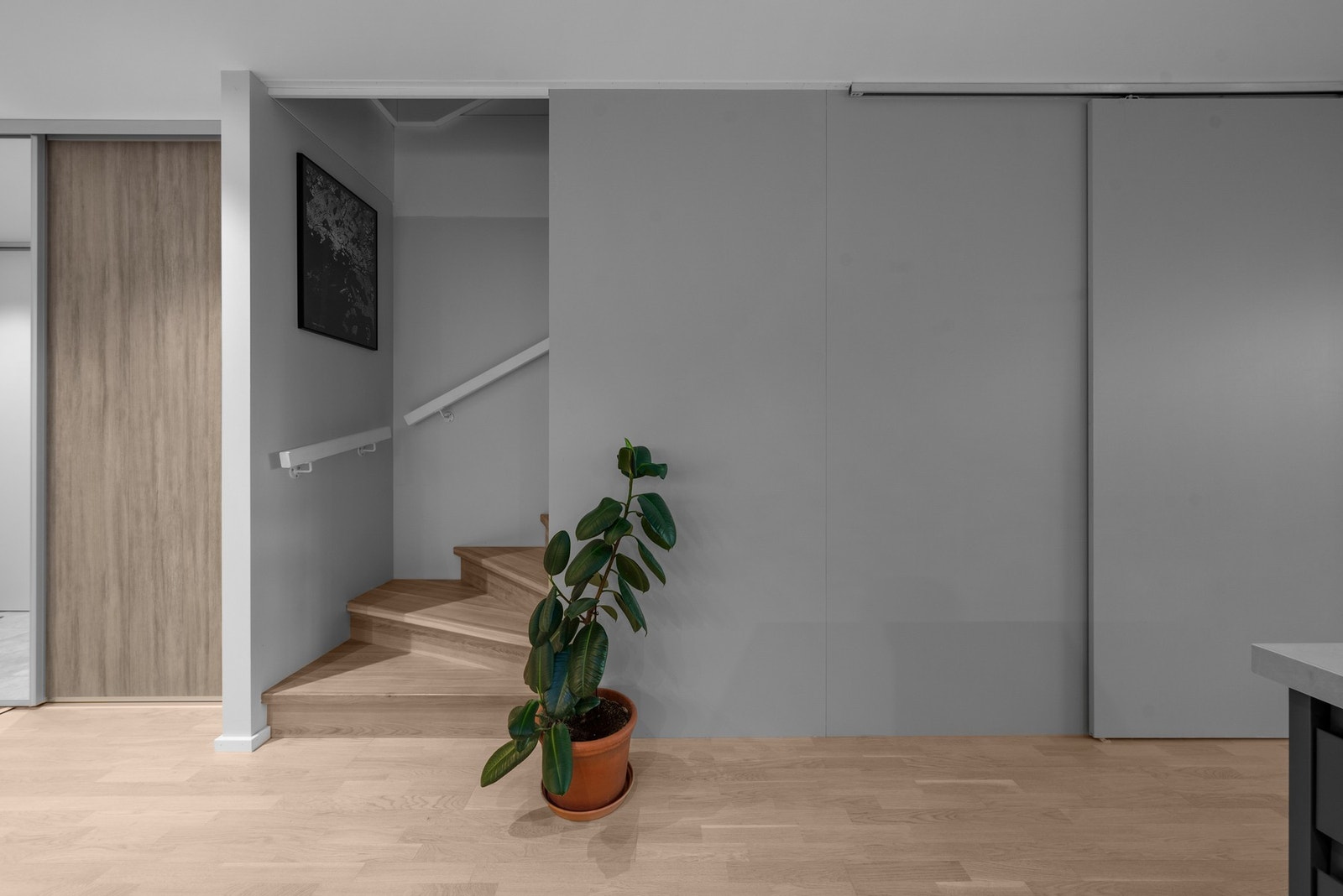 Delikat trappeløsning med lyse overflater og heltre trinn. Videre er det godt med lagringsplass i en skyvedørsgarderobe. Galleribilde