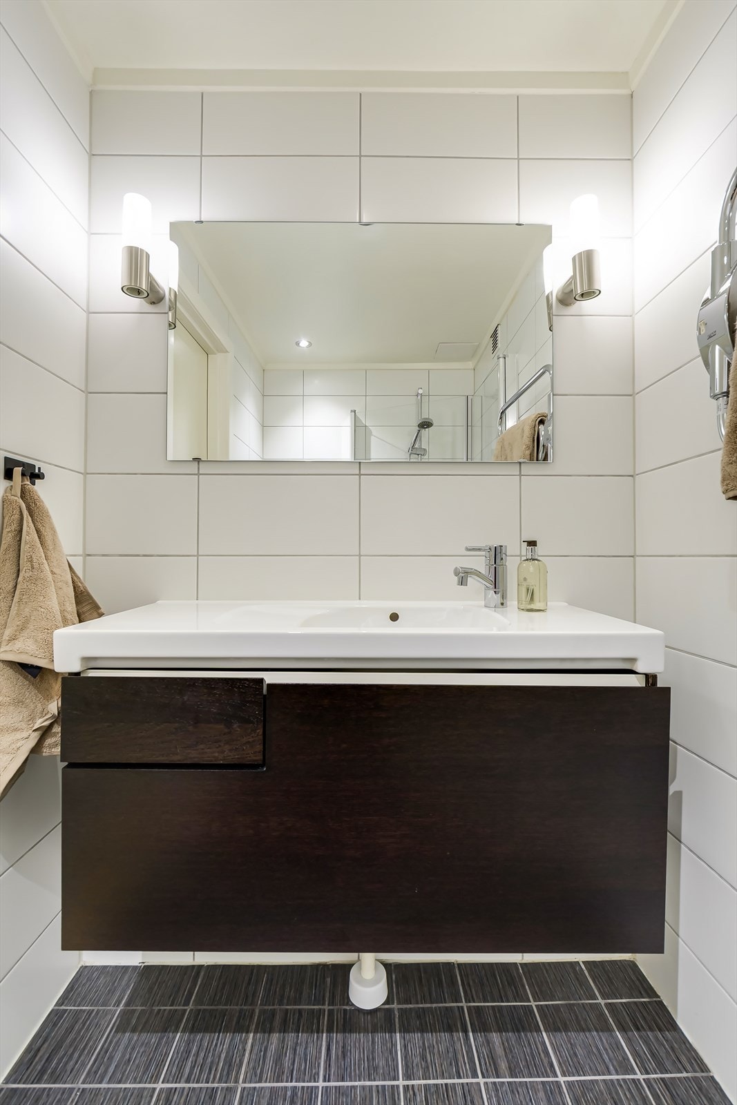 Speil med lys på hver side og stor servantinnredning med god oppbevaringsplass. Galleribilde