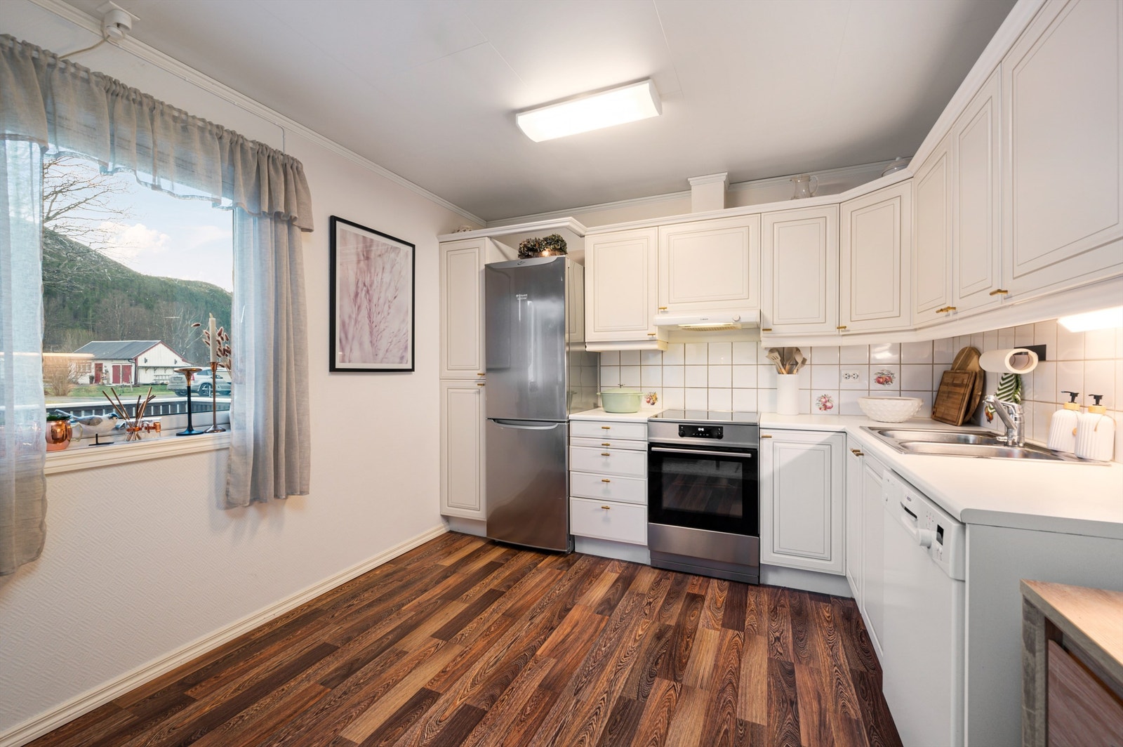 Kjøkkenet ligger naturlig tilbaketrukket fra stuen og er innredet med lyse slette flater og benkeplate av laminat. Galleribilde