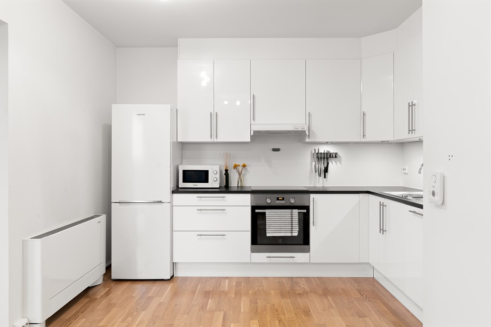 Flott kjøkkeninnredning fra Aubo i hvit utførelse med integrert koketopp, komfyr og oppvaskmaskin. Galleribilde