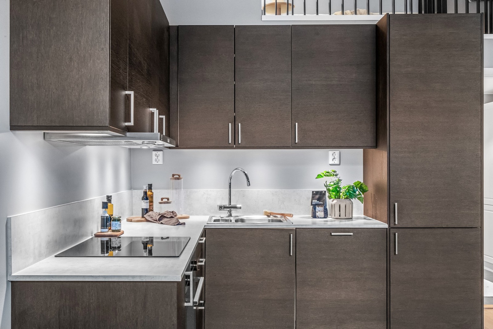 Pent kjøkken med integrerte hvitevarer og rikelig med skap- og benkeplass Galleribilde