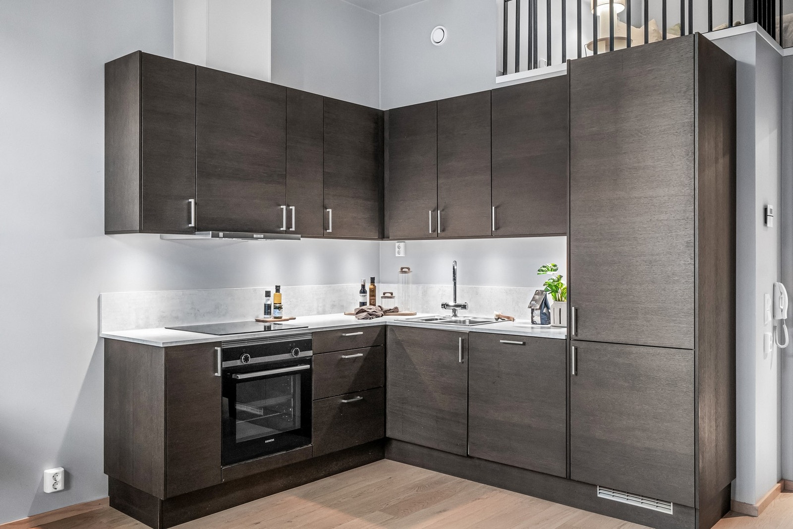 Pent kjøkken med integrerte hvitevarer og rikelig med skap- og benkeplass Galleribilde