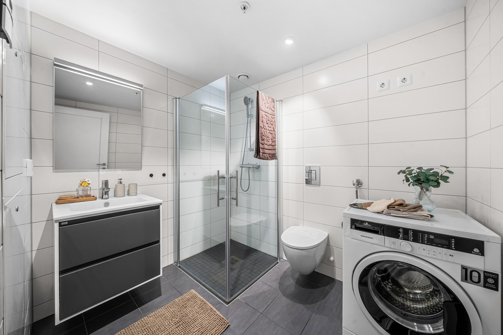 Delikat baderom med gulvvarme og opplegg for vaskemaskin Galleribilde