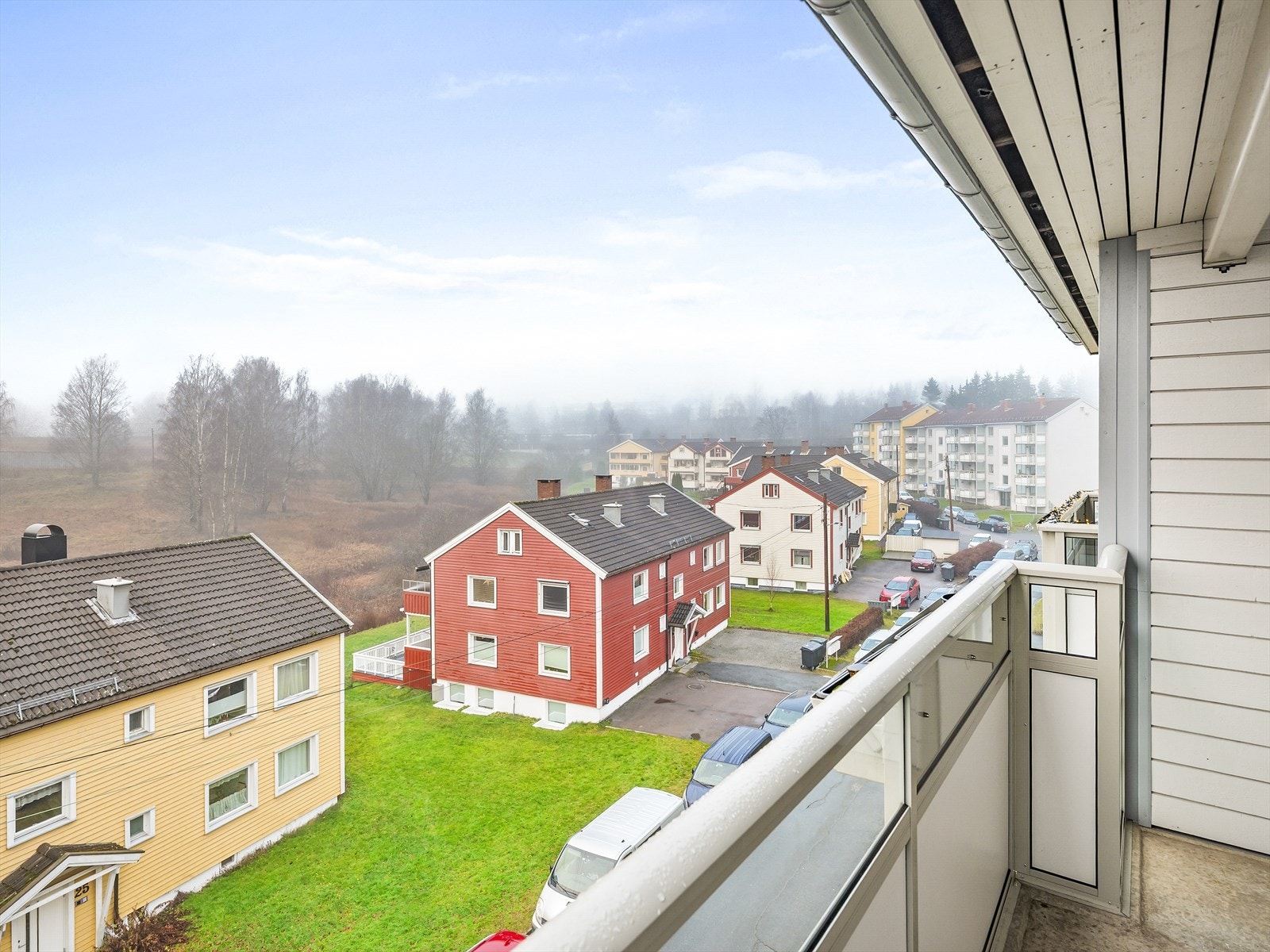 Balkongen har dekke av betong og et rekkverk i glass og aluminium. Galleribilde