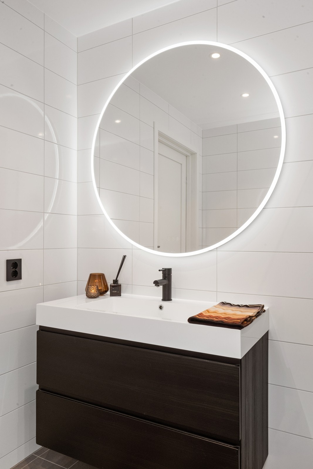 Baderomsinnredningen har skuffer for oppbevaring og et speil med integrert belysning. Galleribilde