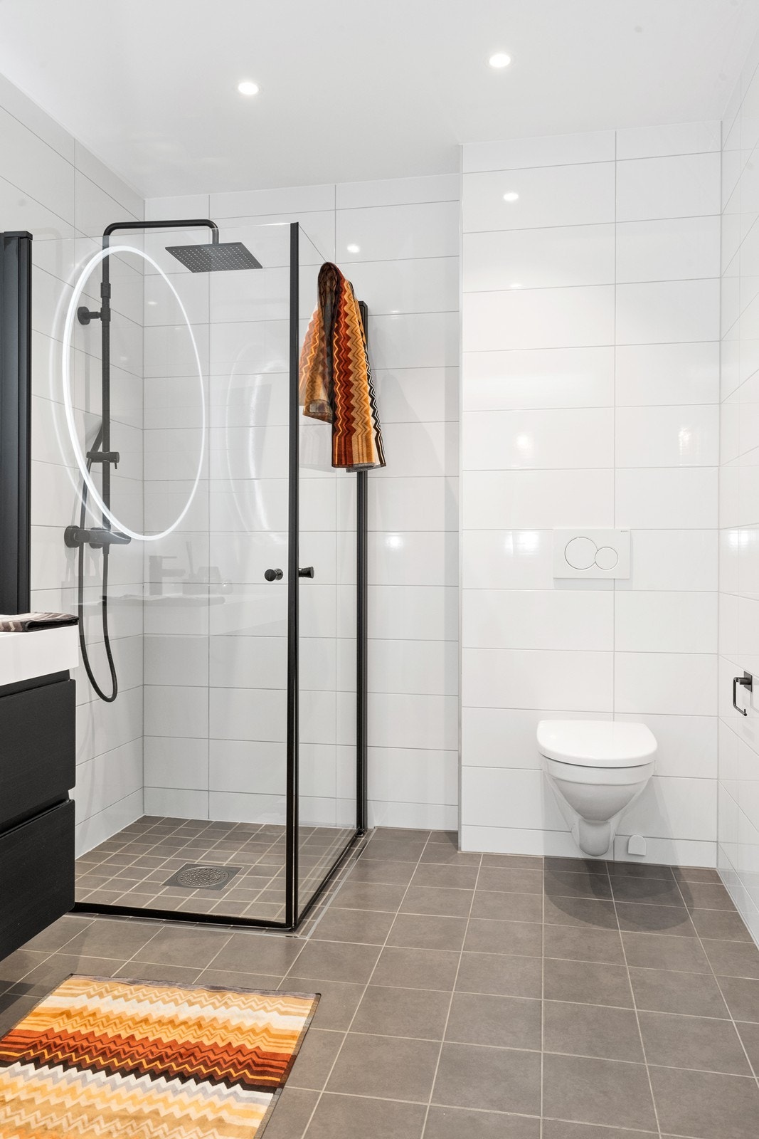 Badet er helfliset med varme i gulvet, vegghengt toalett og dusjhjørne med glassdører. Galleribilde