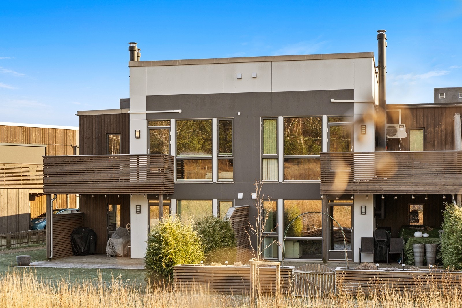 Moderne arkitektur med en kombinasjon av trepanel og slette fasadeplater. Galleribilde