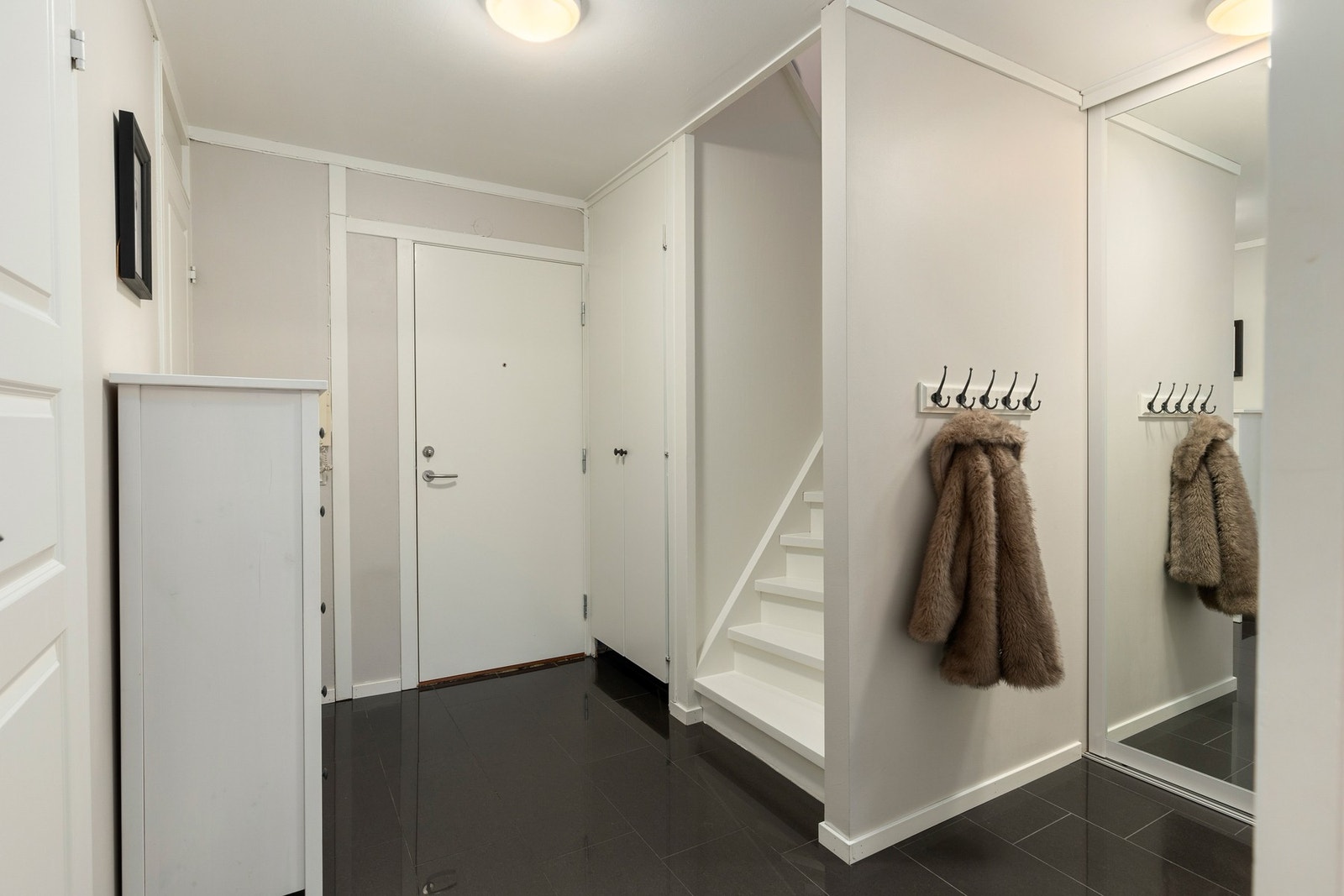 Innbydende entré med plass til å henge fra seg yttertøy og sko Galleribilde