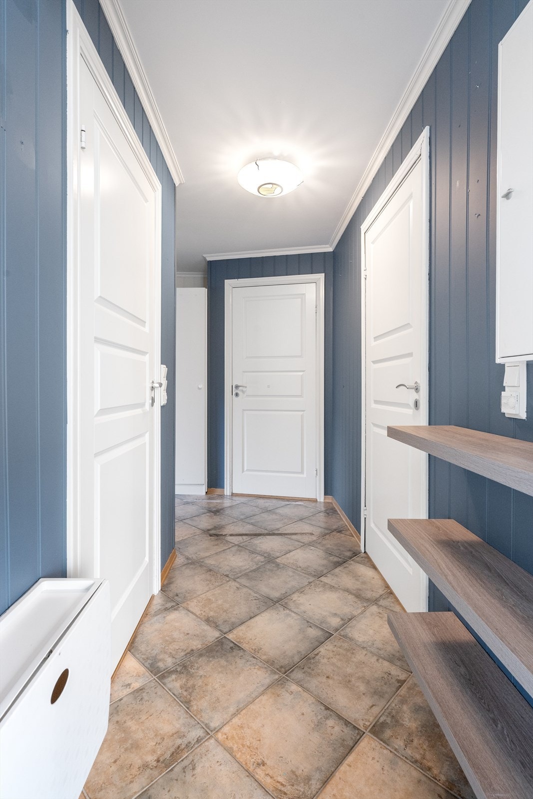 Med adkomst fra felles overbygget inngangsparti kommer man inn i gangarealet hvor det er flislagt gulv med varmekabler. Sikringsskapet er plassert i yttergang. Galleribilde