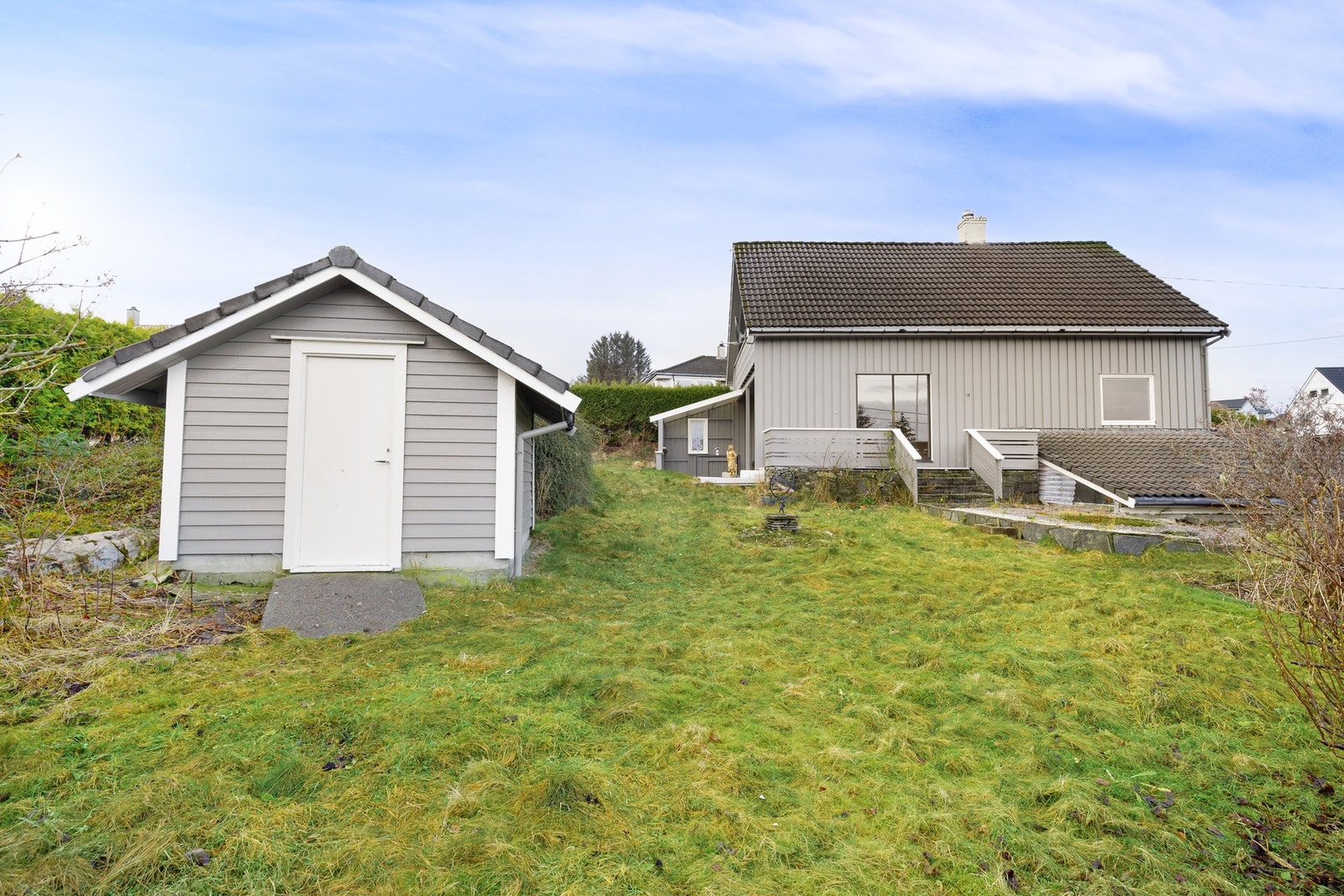 Uthuset gir ekstra lagringsplass eller kan benyttes til hobbyformål, og carport sørger for praktisk parkering. Galleribilde