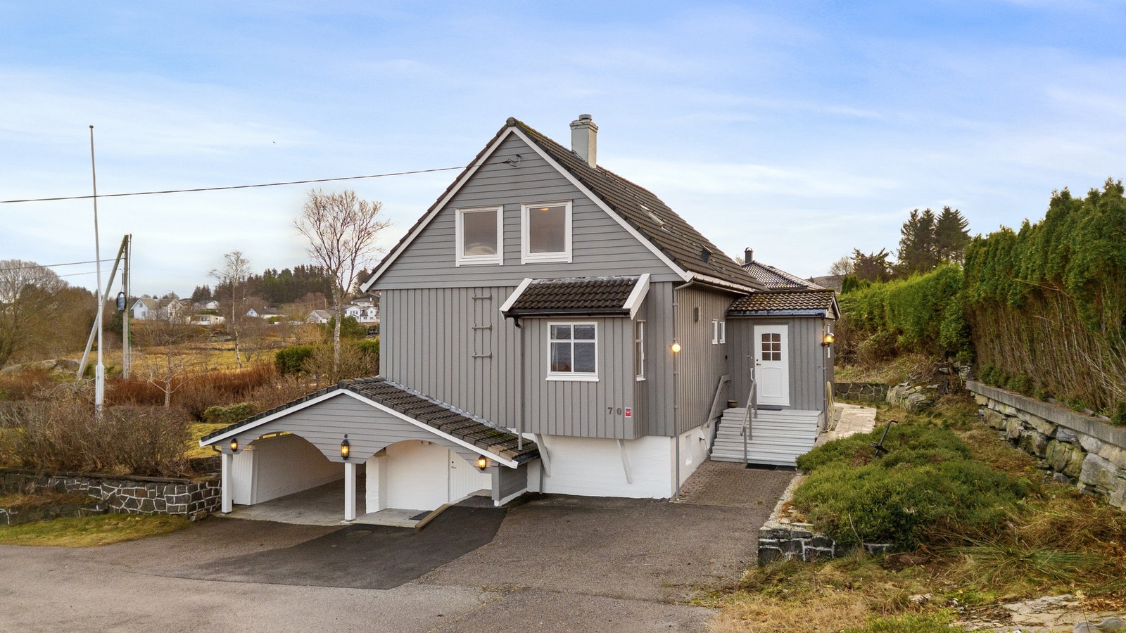 Eiendommen byr på store uteområder, som gir rikelig med plass til lek, hageprosjekter eller sosiale sammenkomster. Uthuset gir ekstra lagringsplass eller kan benyttes til hobbyformål, og carport sørger for praktisk parkering. Galleribilde