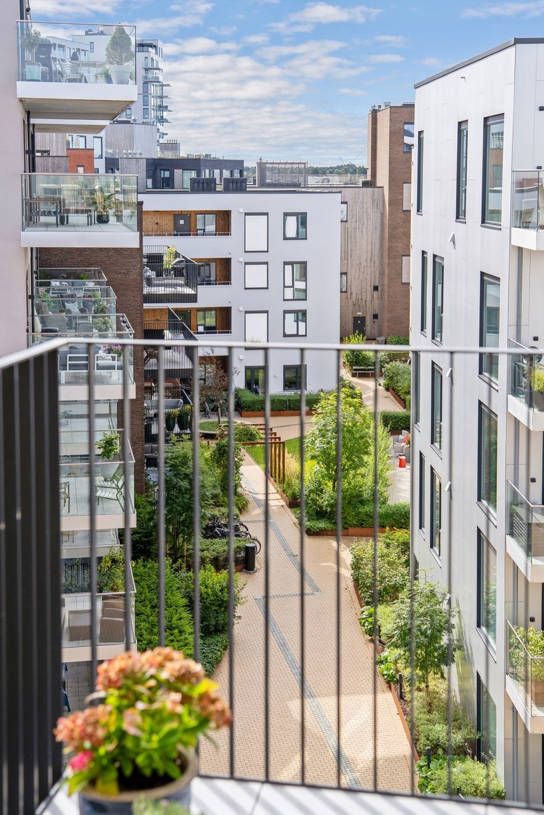Fra balkongen har du flott utsikt utover de mange svært pent opparbeidede uteområende som finnes i Kanalbyen. Legg merke til den flotte beplantningen, gangveiene og sitteområdene. Galleribilde