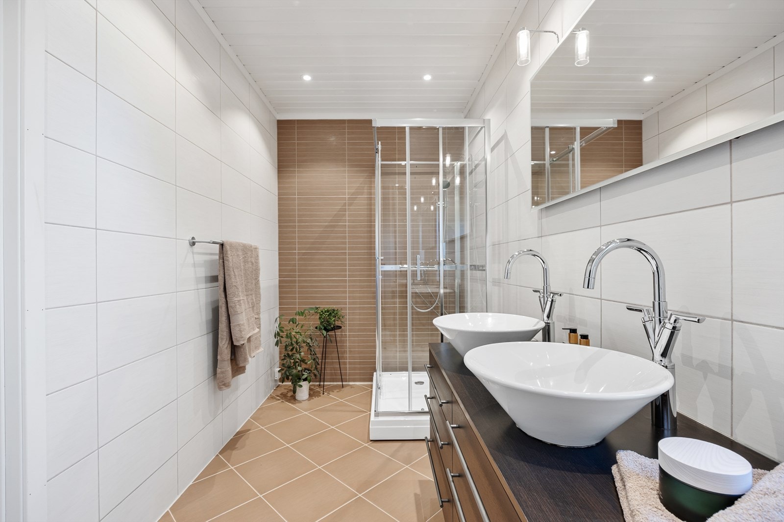 Rommet er utstyrt med dusjkabinett, vegghengt toalett og dobbel servantskap som gir rikelig med oppbevaringsplass. Galleribilde