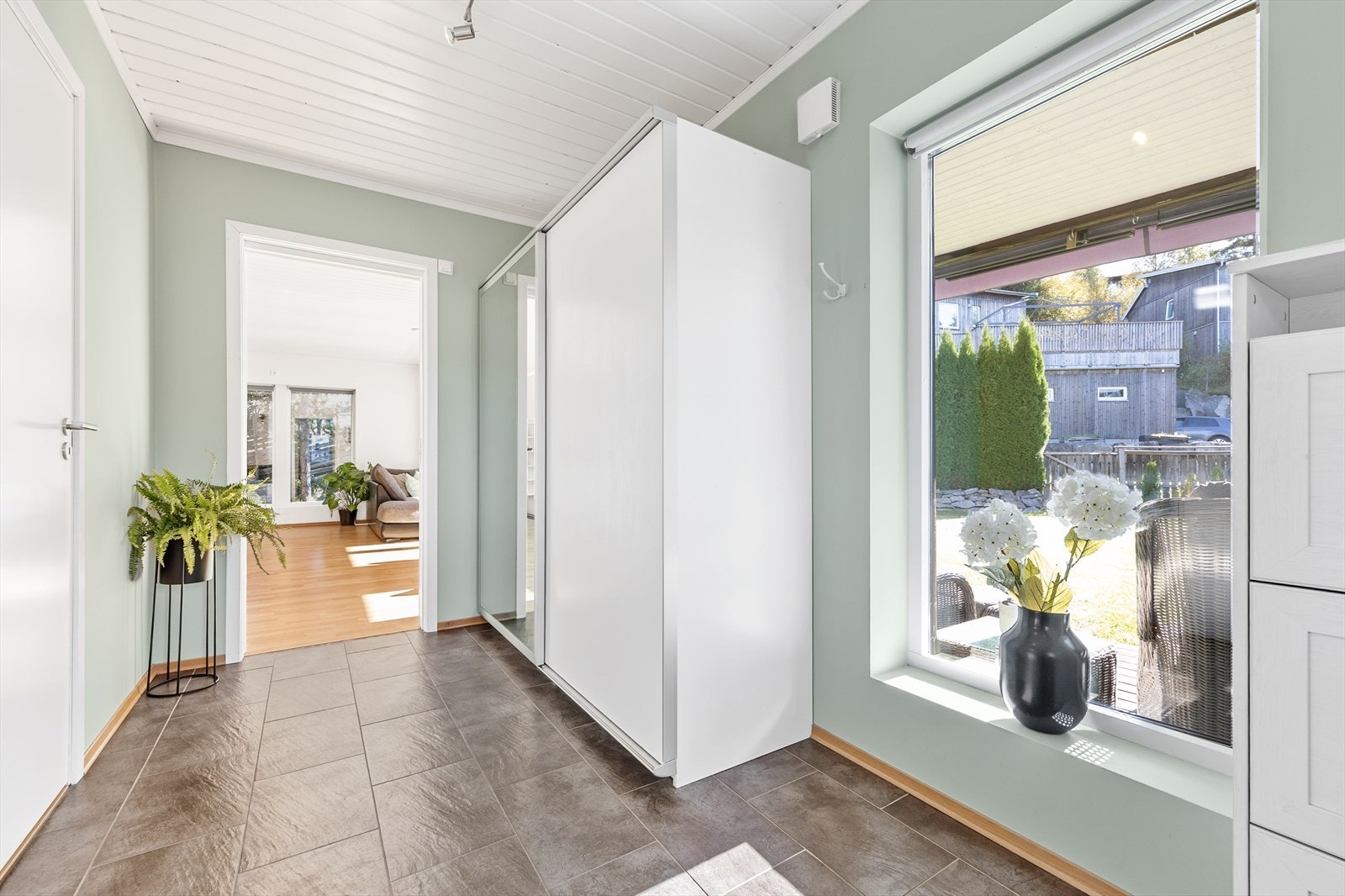 Fra gangen åpner boligen seg opp med en skyvedør i glass inn mot stuen og kjøkkenet. Galleribilde