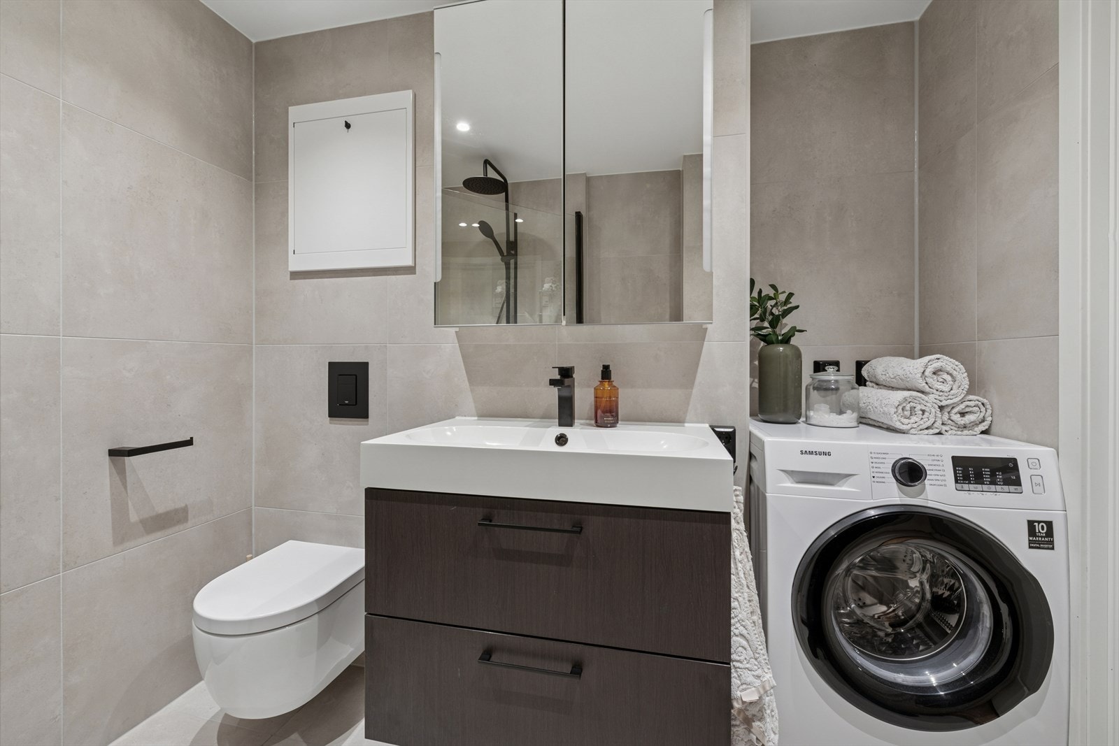 Flislagt bad med god dusj og vaskemaskin som medfølger. Galleribilde