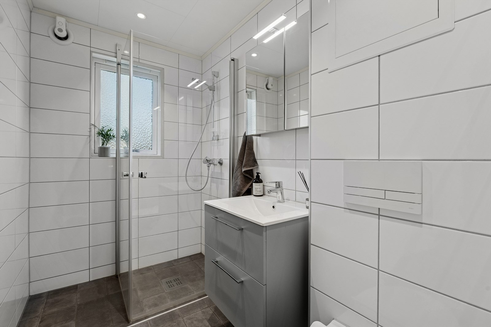 Badet ble renovert i 2021. Det er flislagte gulv og vegger, med el. varmekabler i gulvet. Innredningen består av veggmontert toalett, servant og dusjhjørne. Galleribilde