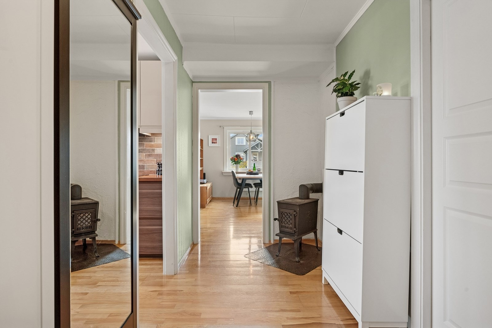 Boligens entré med plass til møblement for oppbevaring og vedovn i hjørnet som skaper en hyggelig atmosfære. Galleribilde