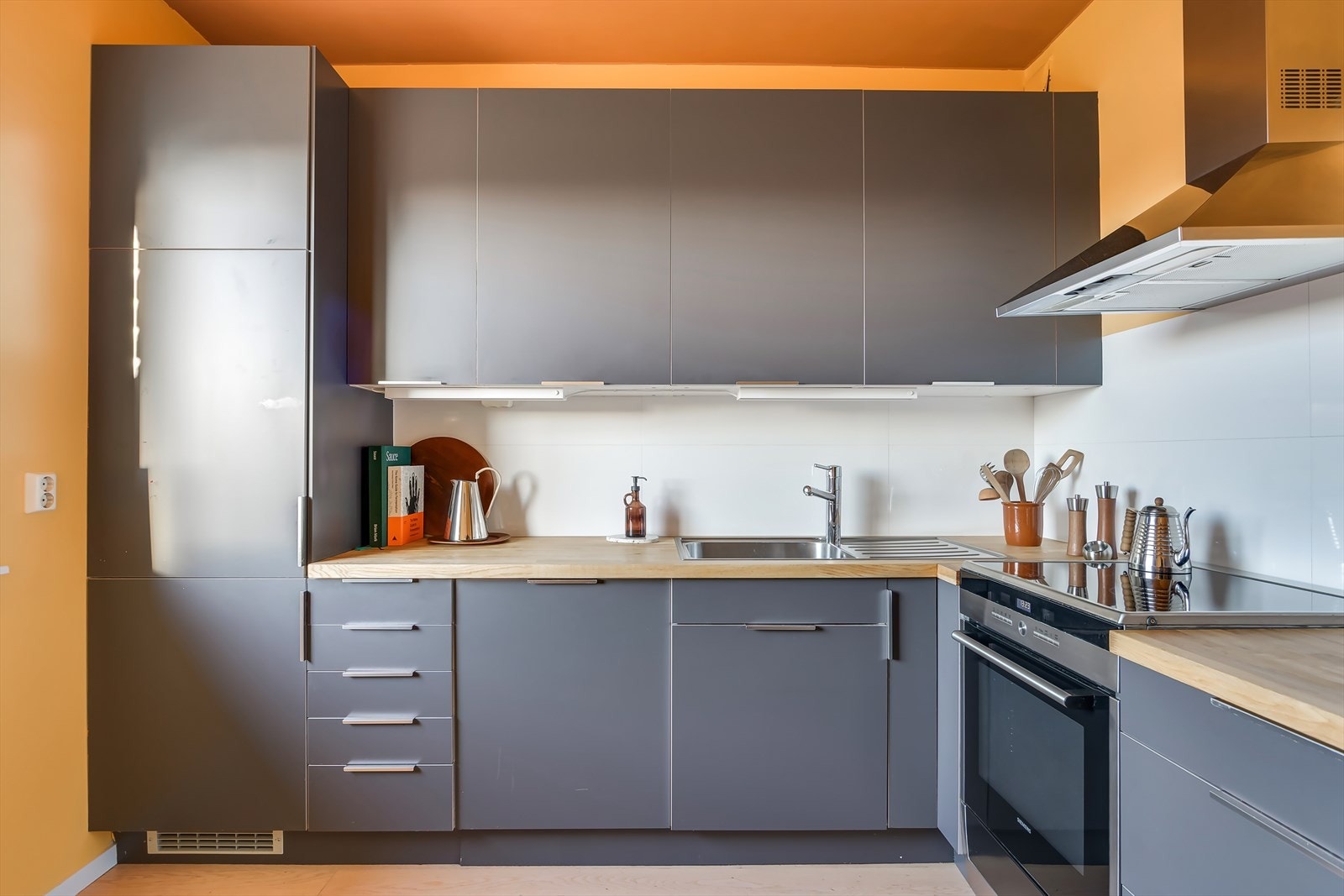 Kjøkkeninnredning med heltre benkeplate og integrert oppvaskmaskin og kombiskap. Galleribilde