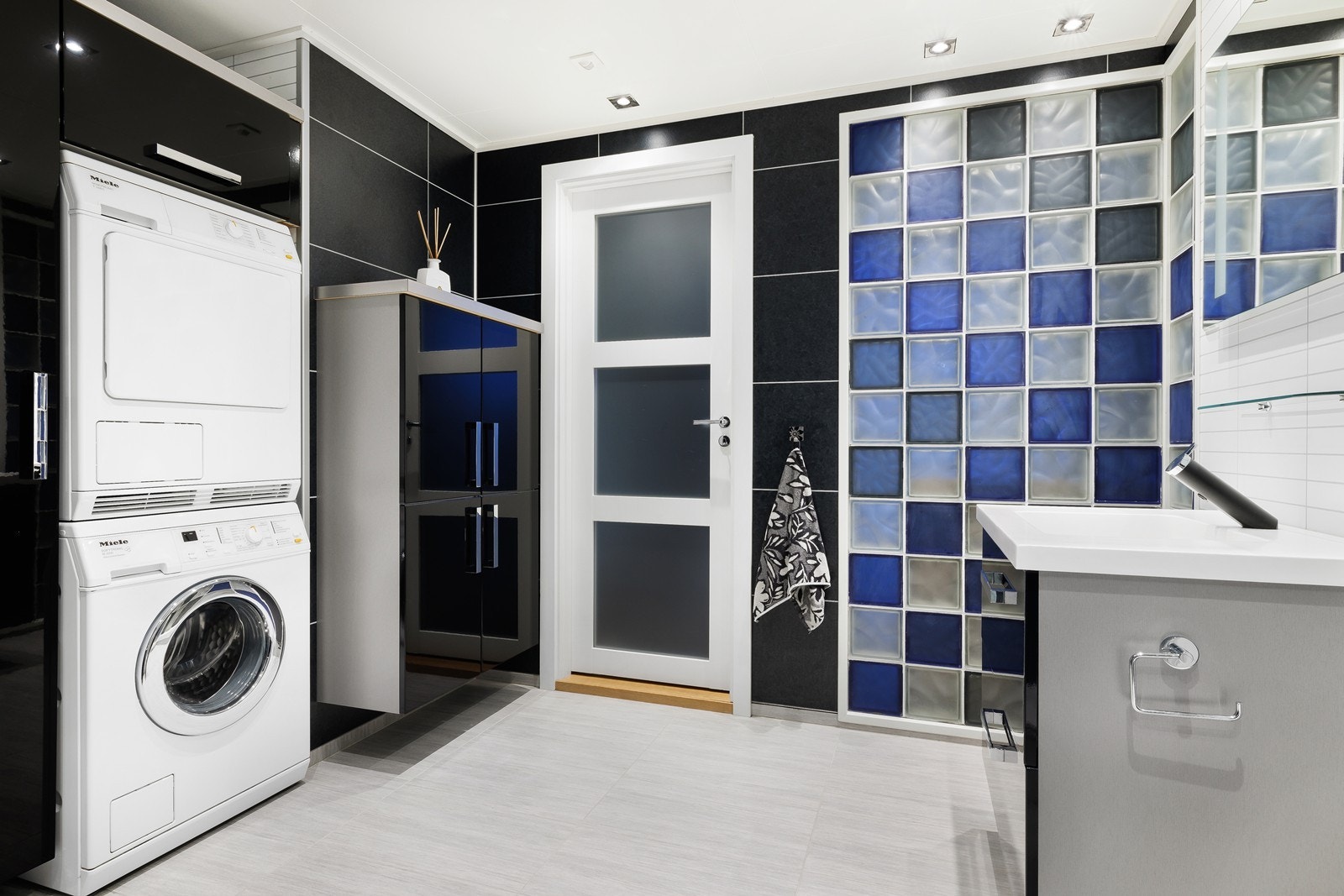 Et praktisk rom utstyrt med vegghengt toalett, vask i servant, dusjhjørne, vask i arbeidsbenk og opplegg til vask og tørk. Galleribilde