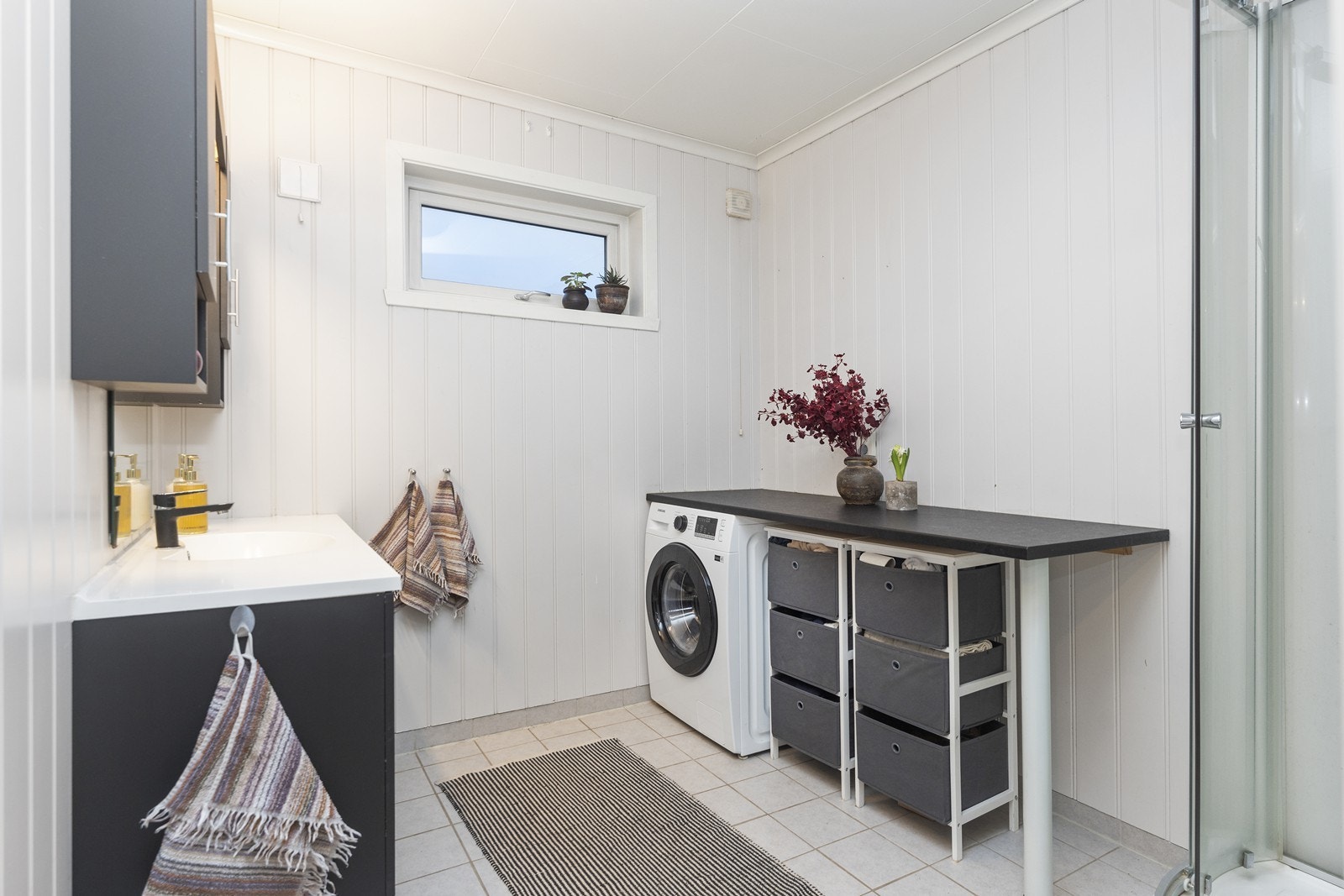 Bad med flislagt gulv og varmekabler. Opplegg til vaskemaskin og praktisk benk. Galleribilde