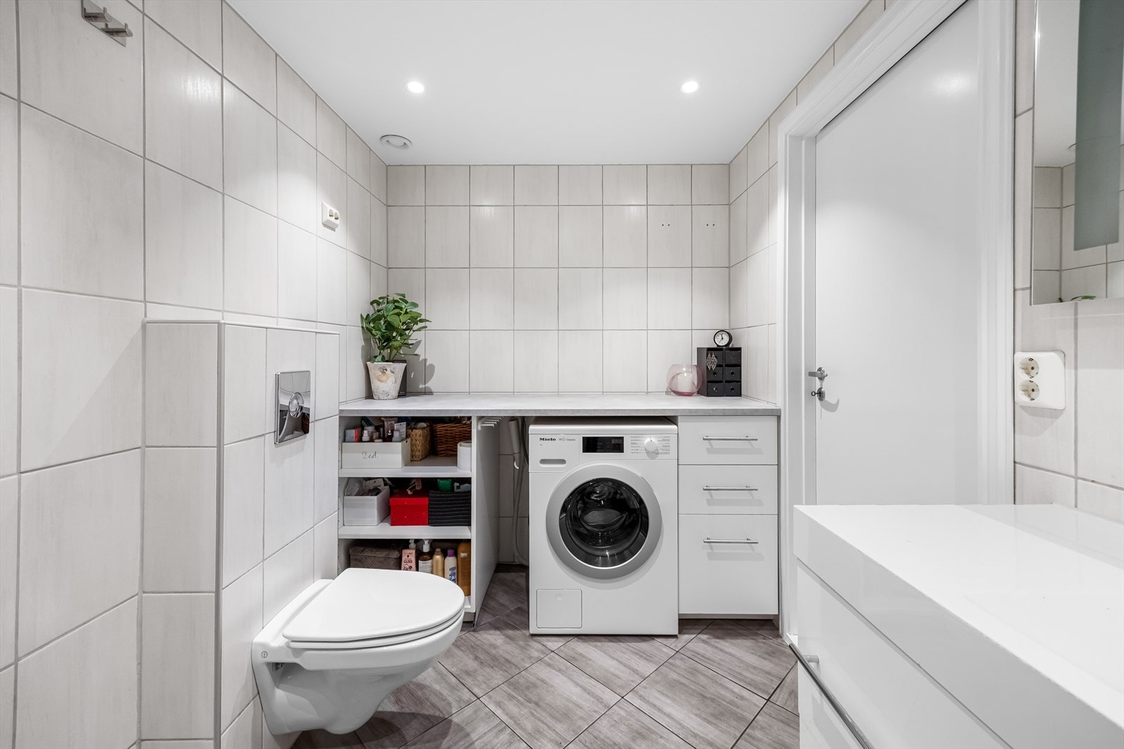 Badet har en praktisk benk med oppbevaring og med plass til vaskemaskin. Badet har mekanisk avtrekk og med luftespalte under døren for tilfredsstillende lufttilførsel. Galleribilde