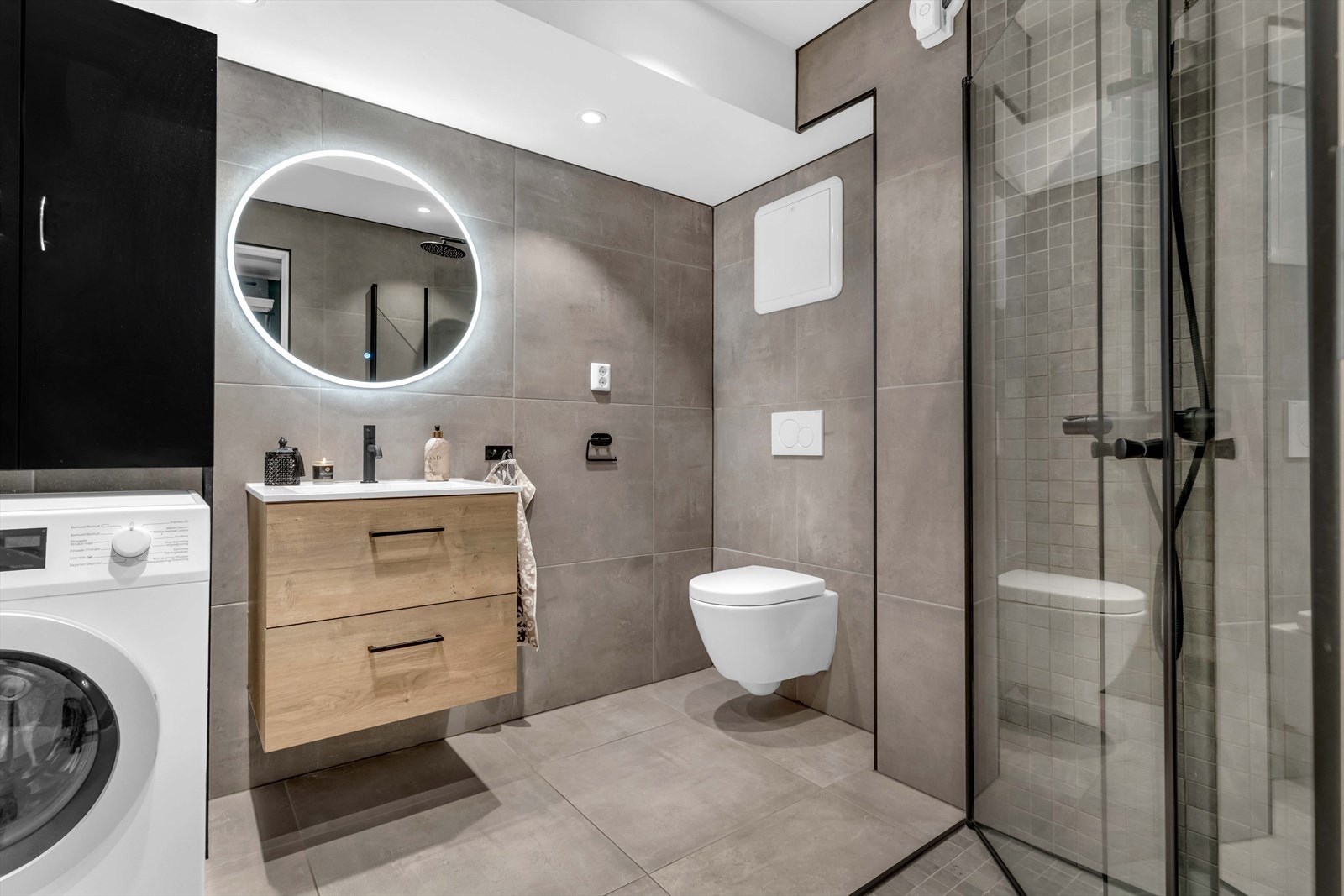 Badet er innredet med blant annet servantskap med nedfelt servant, dusjhjørne med glassdører og vegghengt toalett. Galleribilde