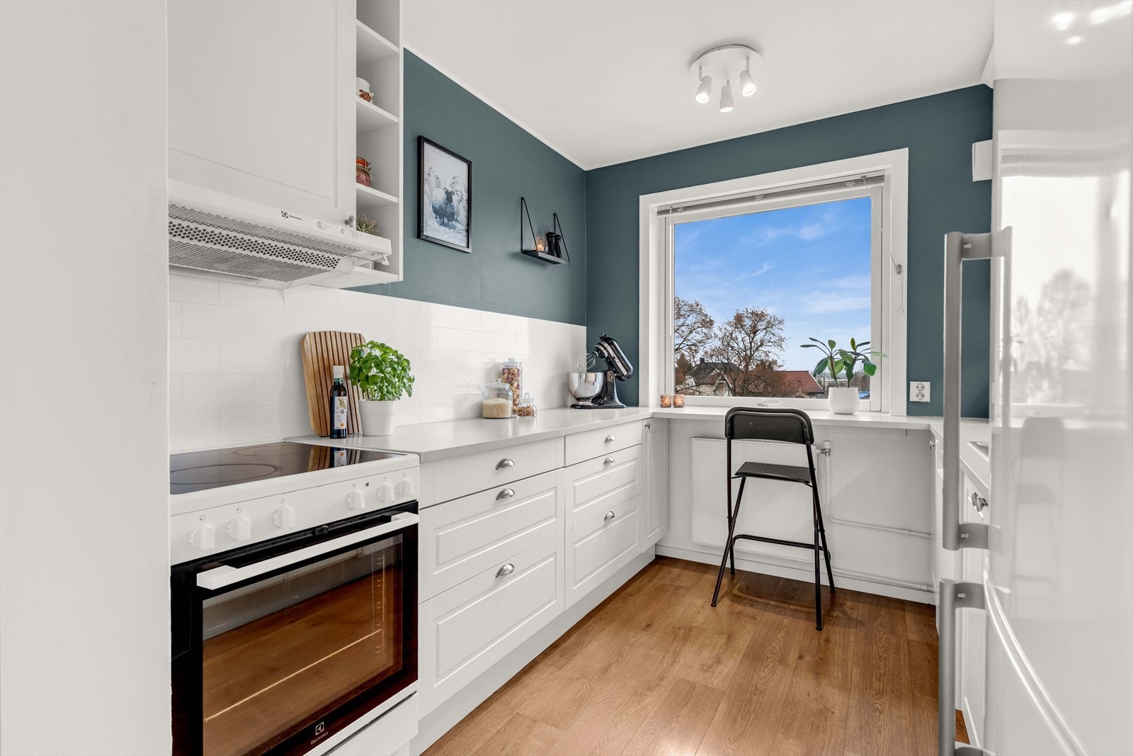 Lyst og romslig kjøkken med profilerte fronter og praktiske løsninger. Galleribilde