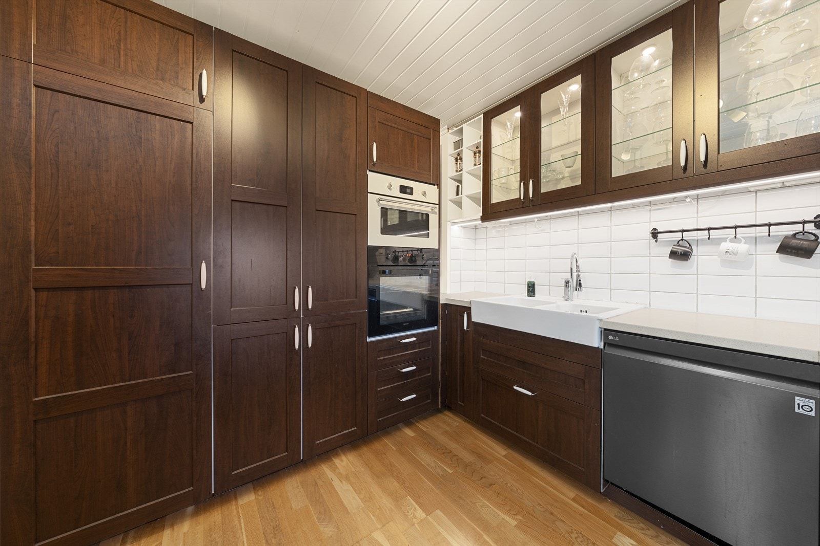 Innredningen har integrerte hvitevarer som oppvaskmaskin, stekeovn, platetopp, mikro og kjøleskap Galleribilde