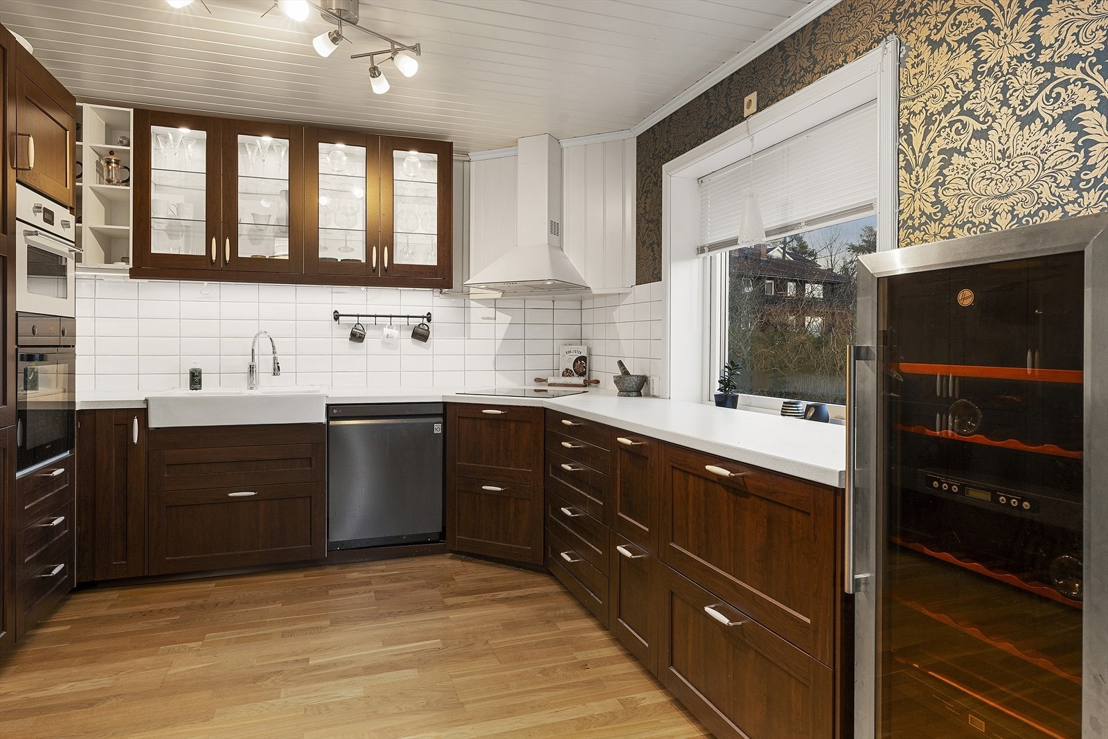 Kjøkkeninnredningen er godt tilpasset rommets utforming og har godt med skap- og benkeplass Galleribilde