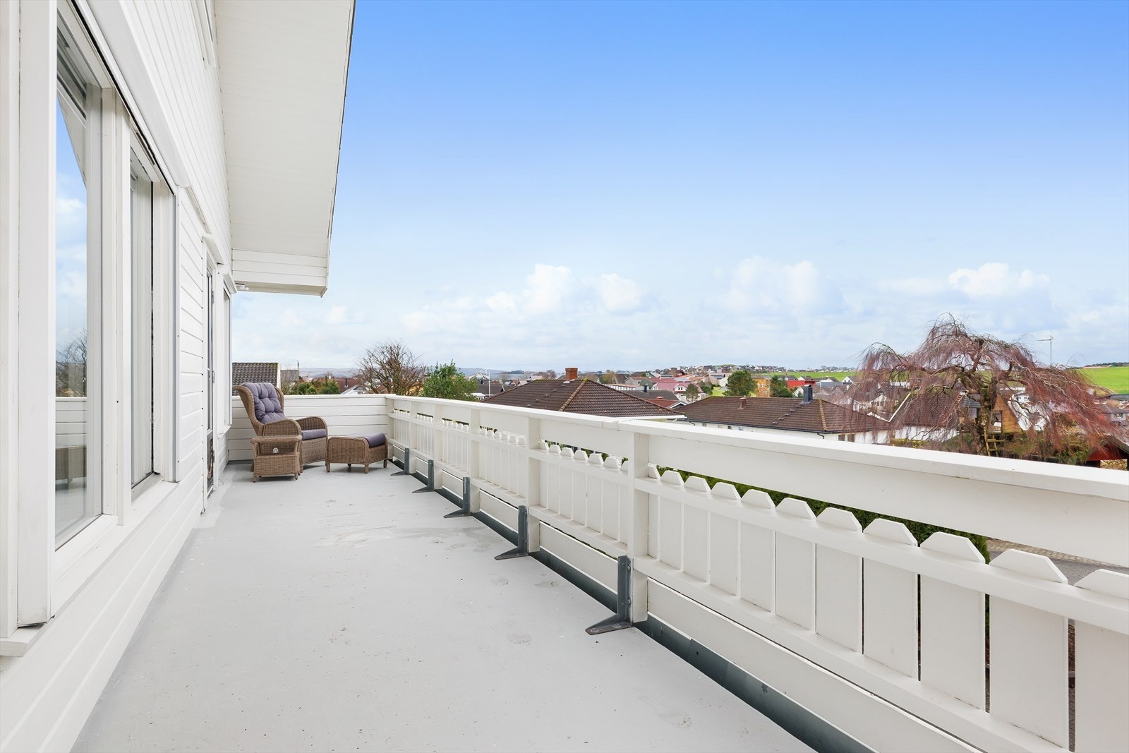 Balkong ut fra stuen, som leder videre til terrassen og hagestuen Galleribilde