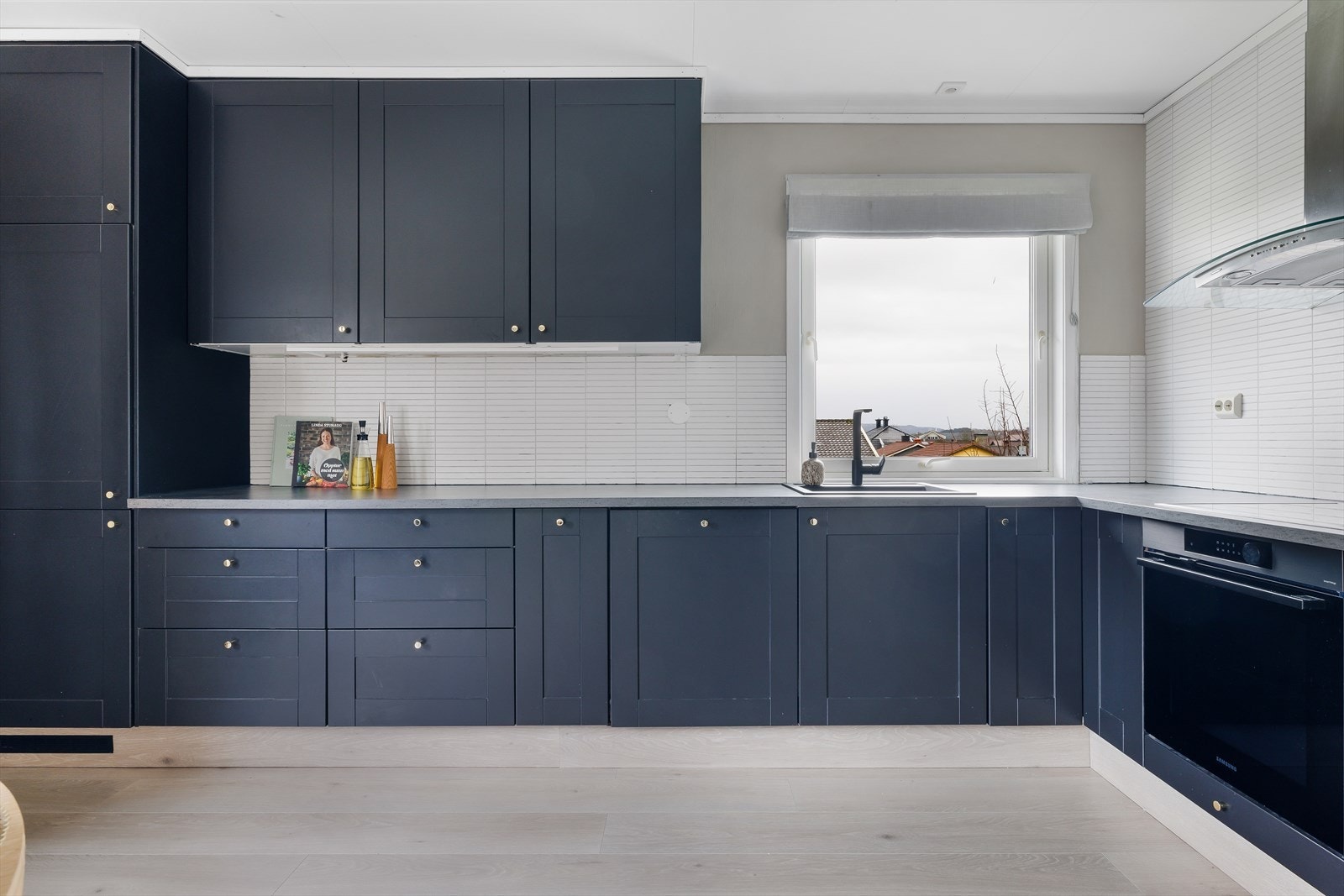 God skap-og benkeplass, integrerte hvitevarer og kjekk vindusløsning på kjøkken Galleribilde