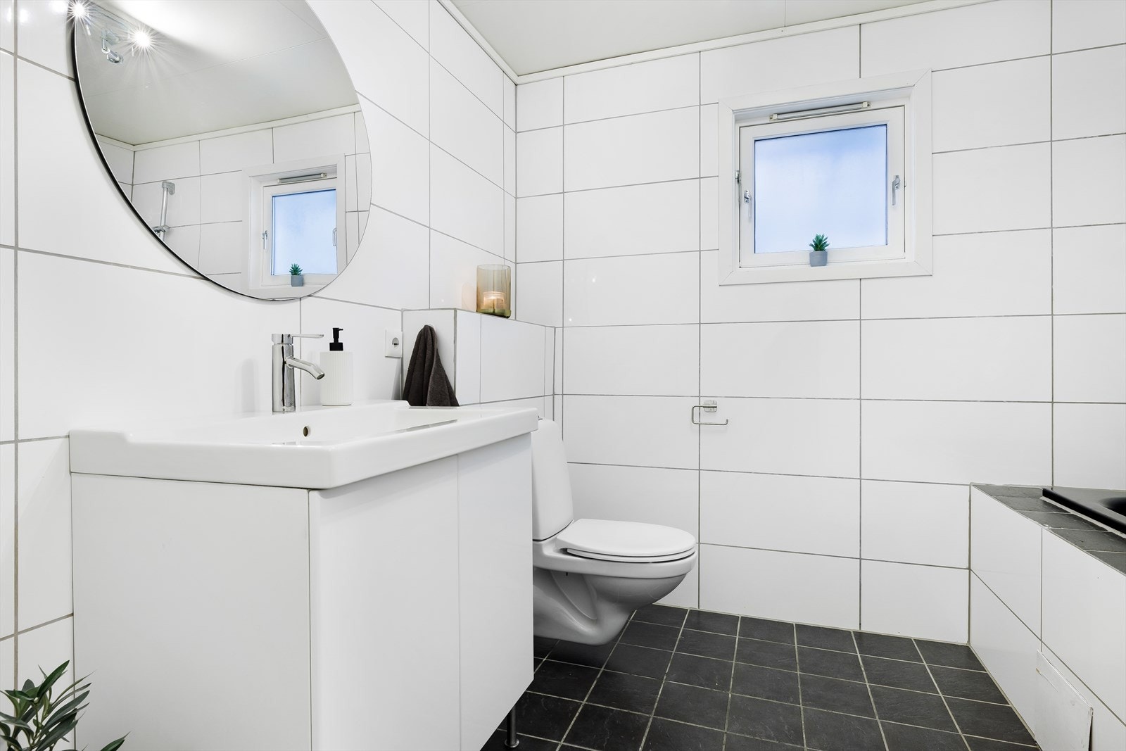 Bad i 1. etasje har vegghengt wc, vask i seksjon og badekar Galleribilde