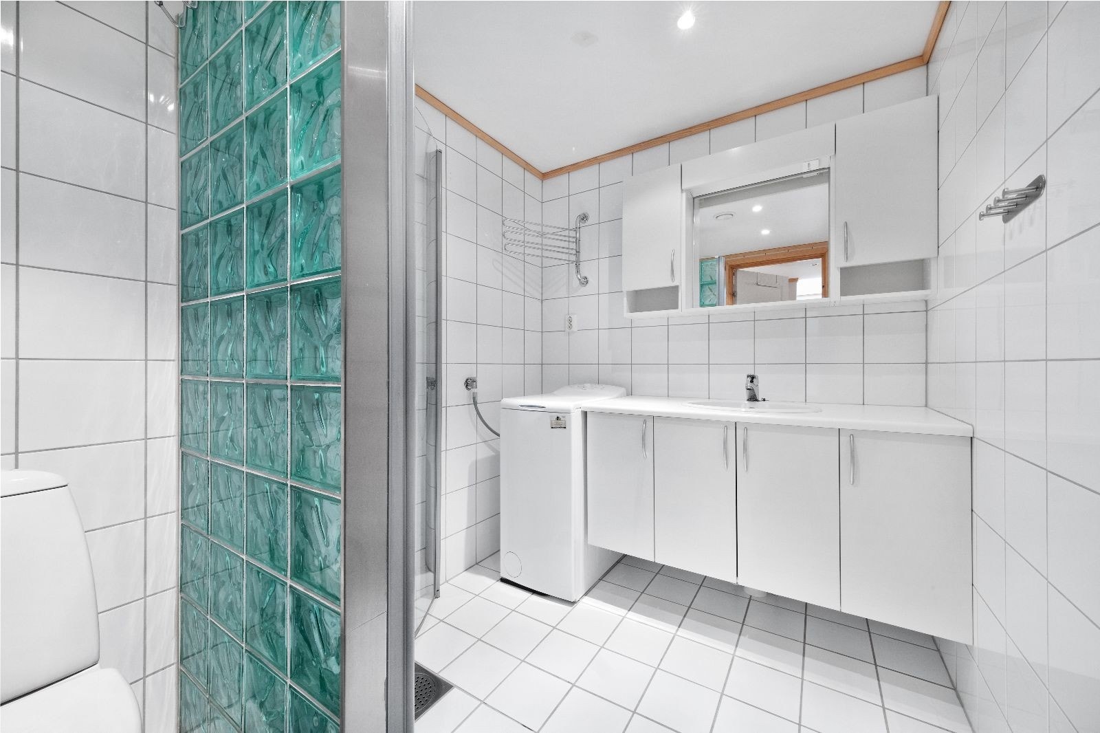 Flislagt bad med innfellbare dusjdører, WC og varme i gulv. Galleribilde