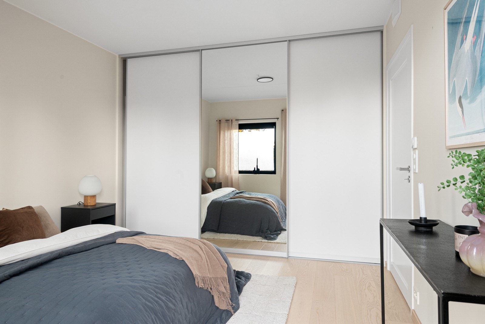 Rommet er malt i duse, tidsriktige farger og har en plassbesparende skyvedørsgarderobe langs hele veggen, som gir rikelig med klesoppbevaring. Galleribilde