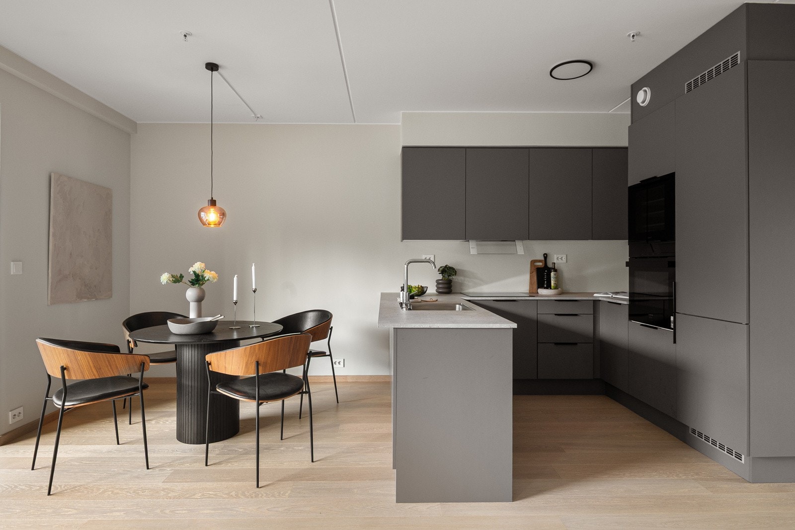 Spisestuen ligger perfekt til ved kjøkkenet, og den åpne løsningen mot stuen skaper et sosialt rom hvor samtaler og måltider flyter naturlig sammen. Galleribilde