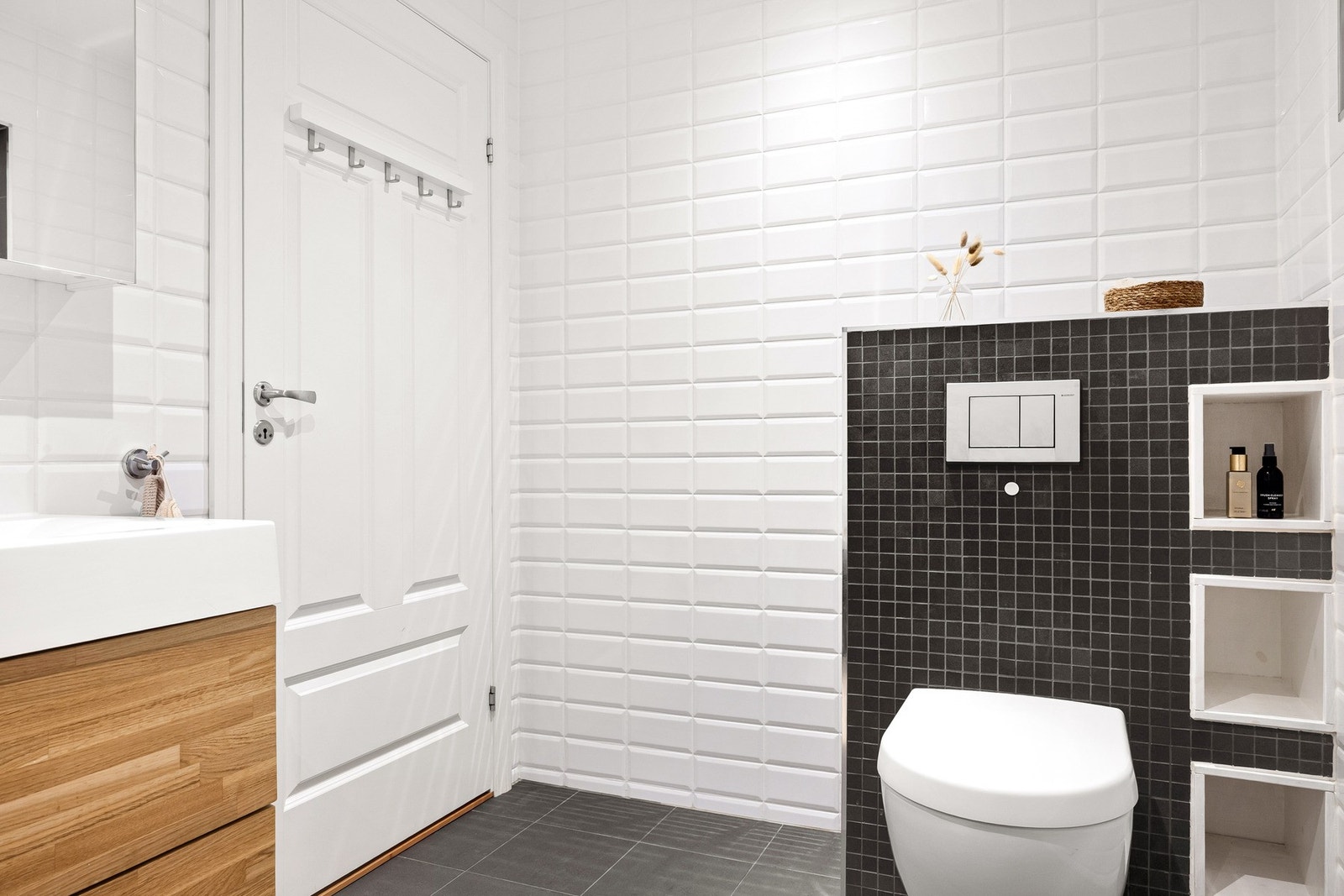 Badet har badekar med dusjvegg, vegghengt toalett og baderomsinnredning. Galleribilde