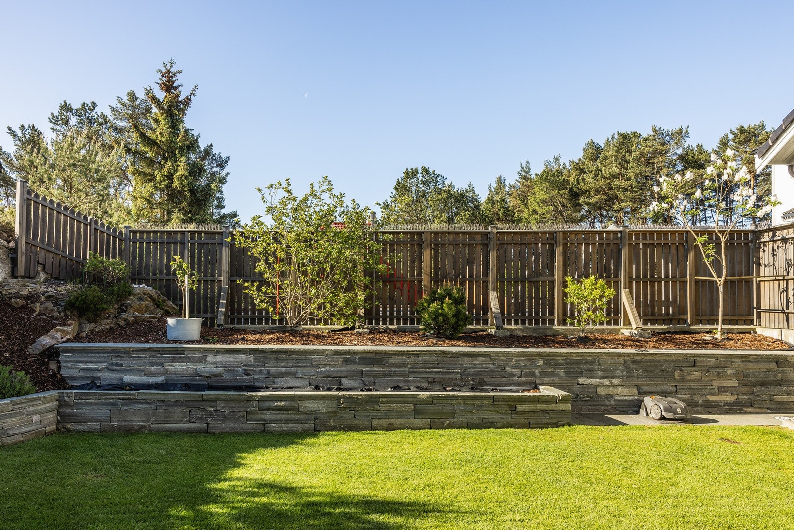 Flott og grønn plen omkranset av en nydelig skifermur. Galleribilde