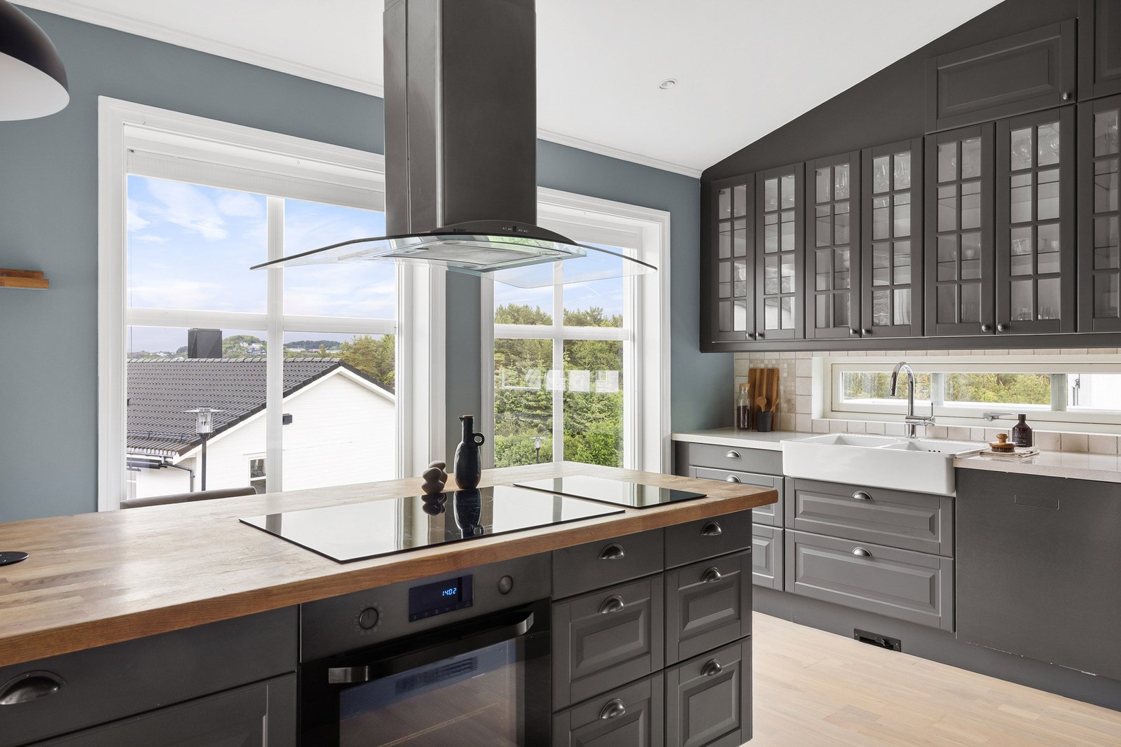 Kjøkkenet har innredning av profilerte fronter i treverk, vask i keramikk, benkeplate av stein og heltrebenkeplate. Galleribilde